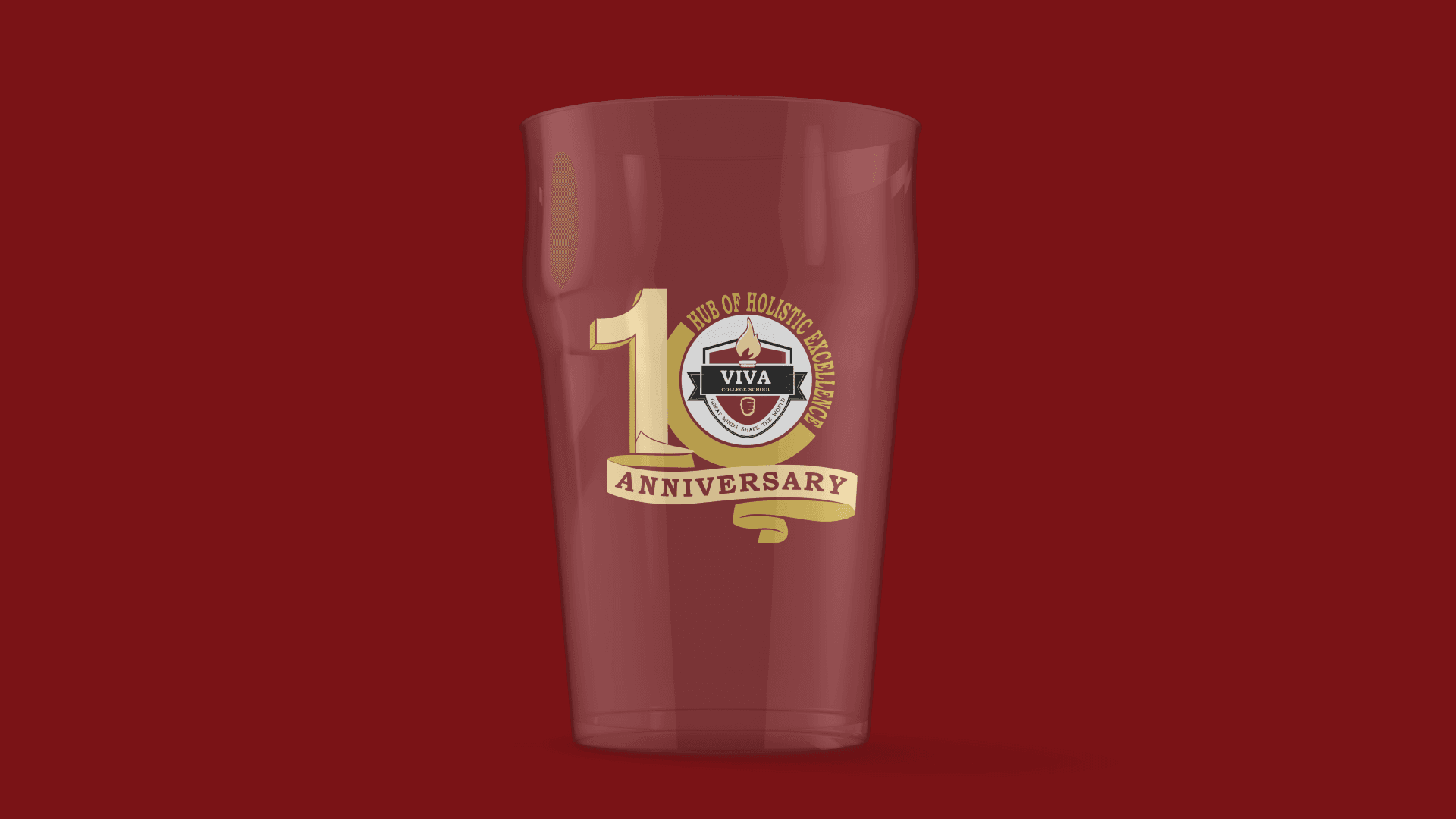 A red glass with a 10th anniversary logo for Viva College School, featuring a flame and shield design, on a red background.