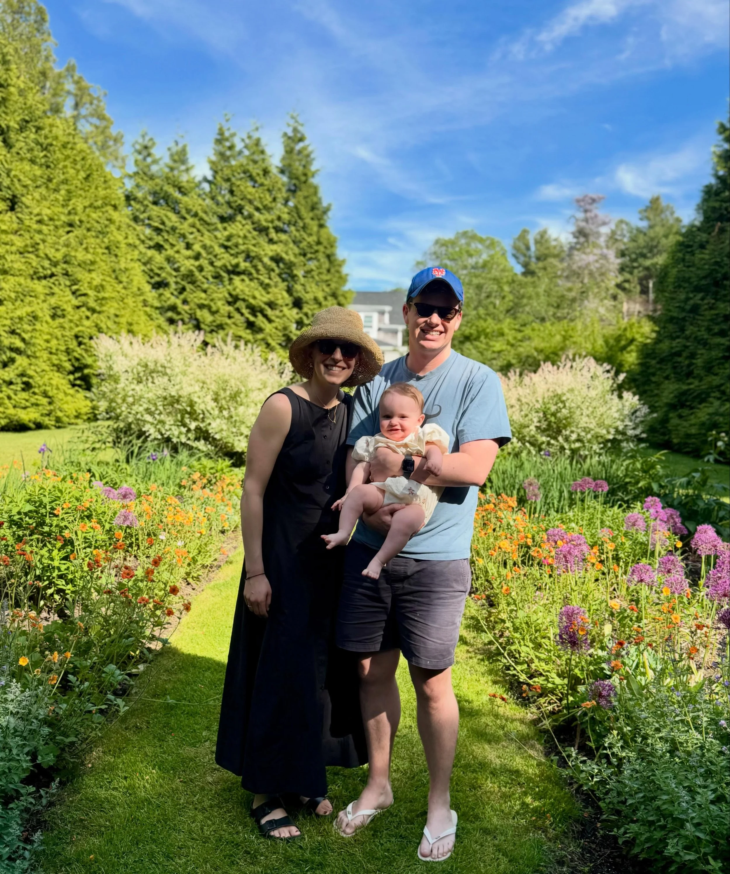 We love it when our couples come back for a visit! @katiecookie9 and @jsomderulo_ with their beautiful 7 month old daughter, Lena, in our English Garden, where they tied the knot two Junes ago! 🪻🪻