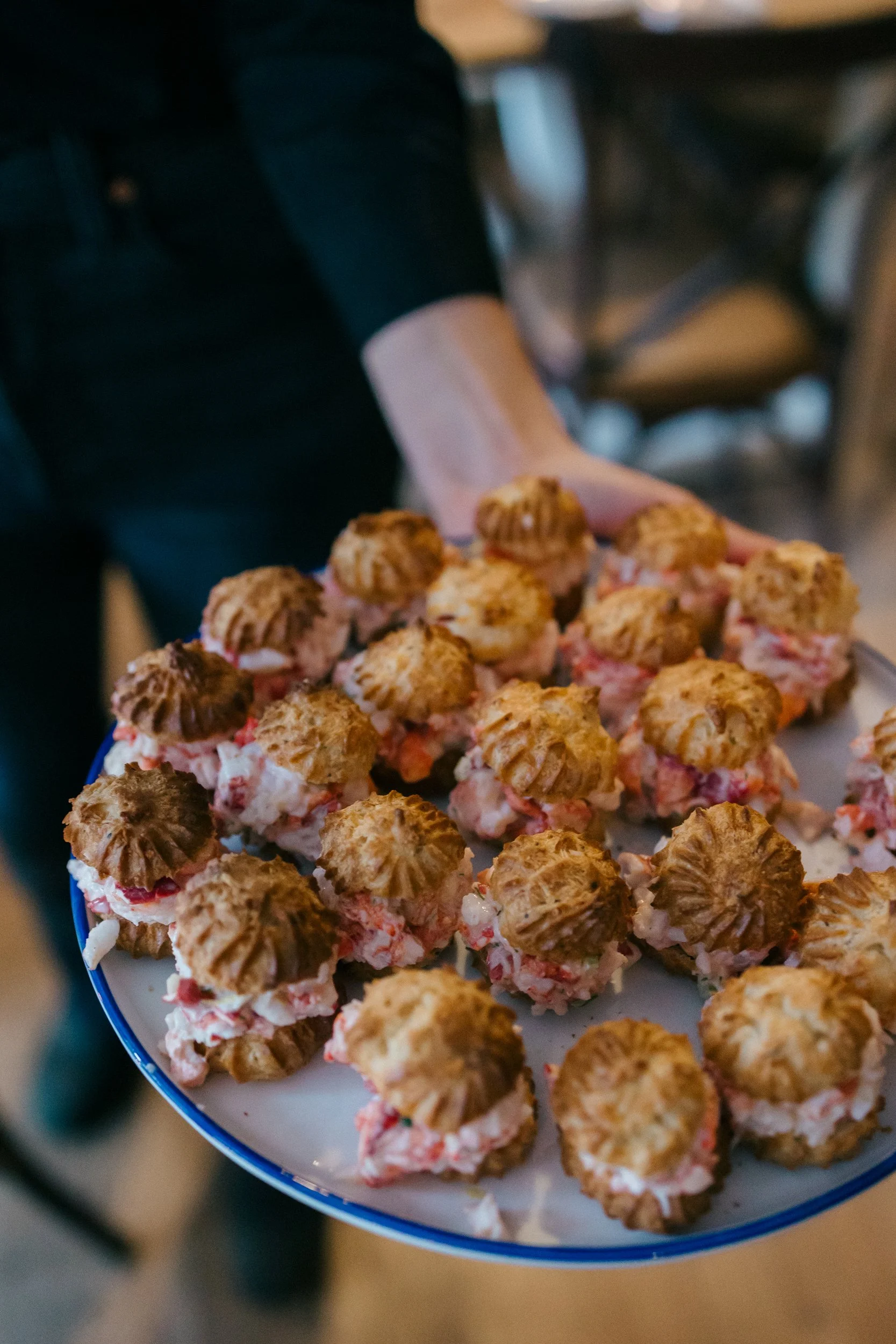 People serving appetizers or hors d'oeuvres on a round tray at a wedding reception at Lambert's Cove Inn on Martha's Vineyard.