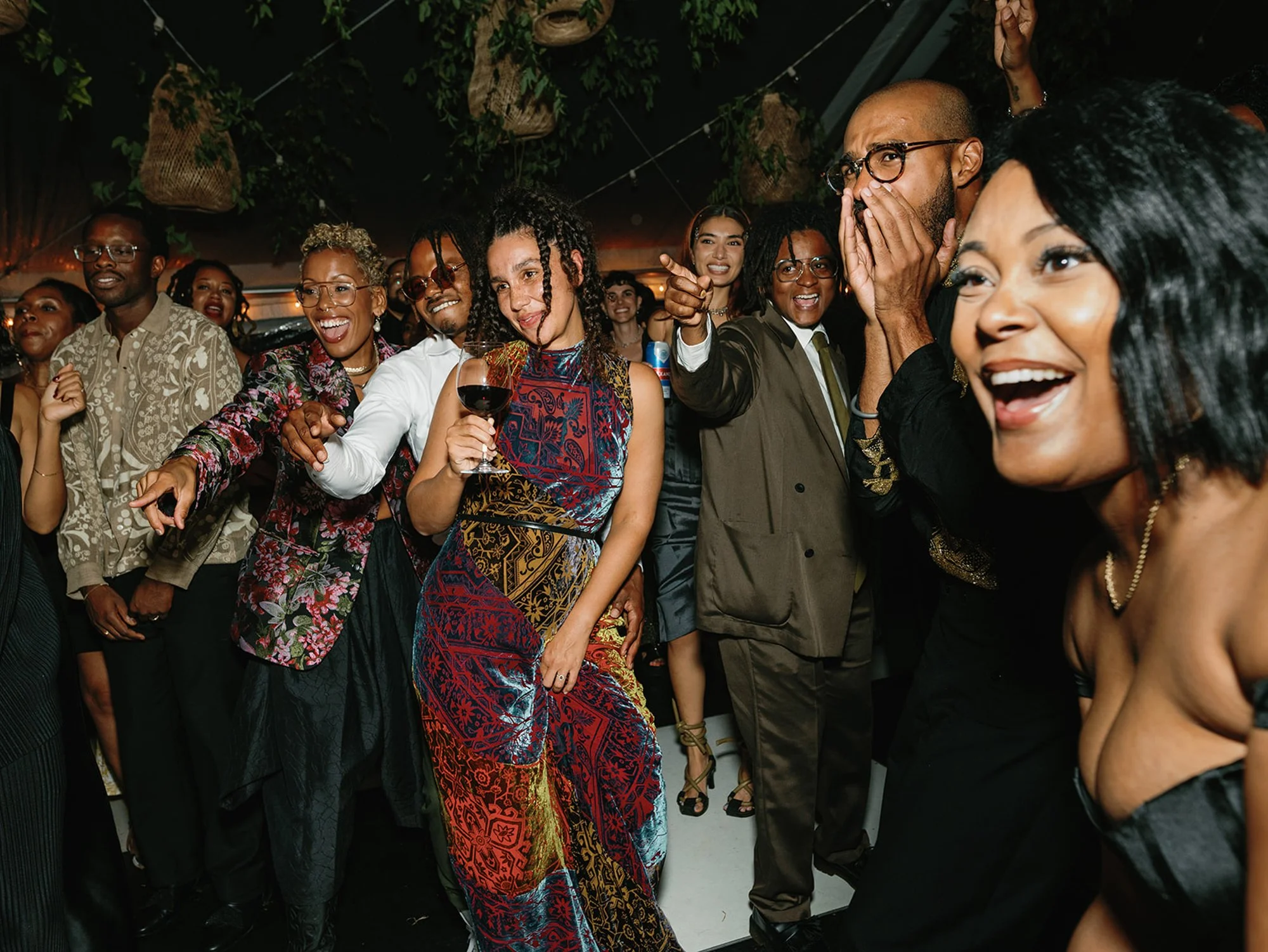 A group of diverse adults at a lively wedding reception at Lambert's Cove Inn on Martha's Vineyard, smiling and enjoying themselves.