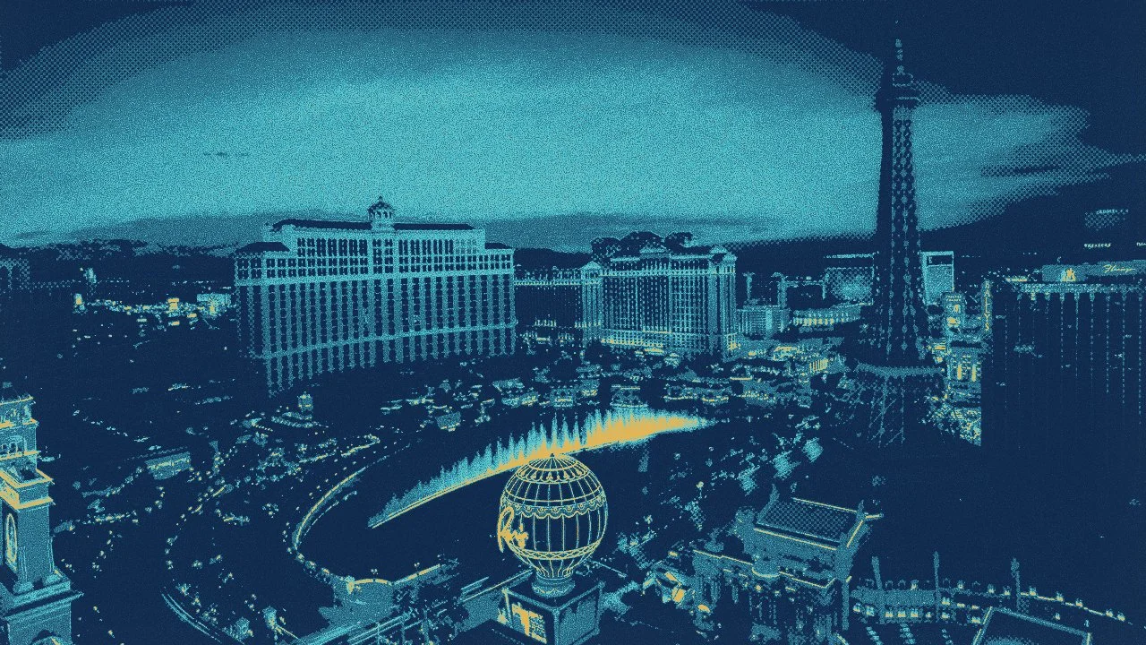 Nighttime view of the Las Vegas Strip with illuminated buildings and the Eiffel Tower replica, featuring a fountain show in the foreground.