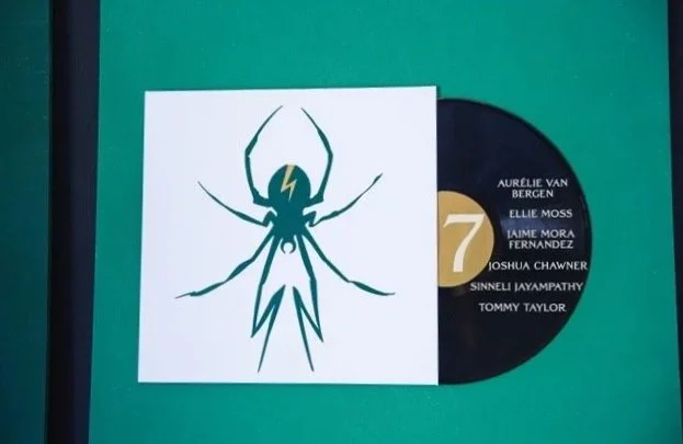 A seating chart featuring a stylised outline of a spider with a lightning bolt on its body, alongside a black vinyl record and a list of names.