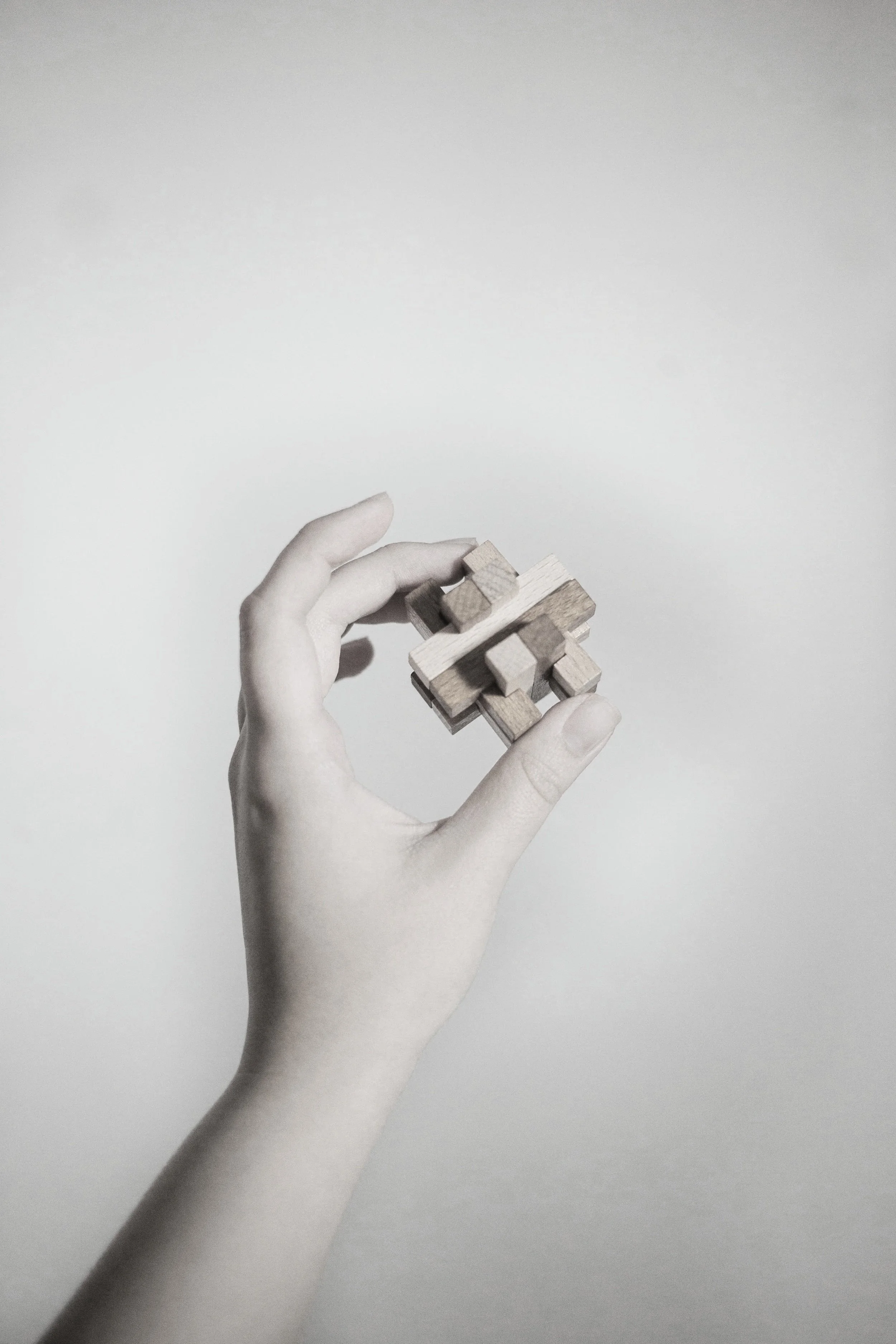 Hand holding a wooden puzzle piece — customized safety program solutions by CORE