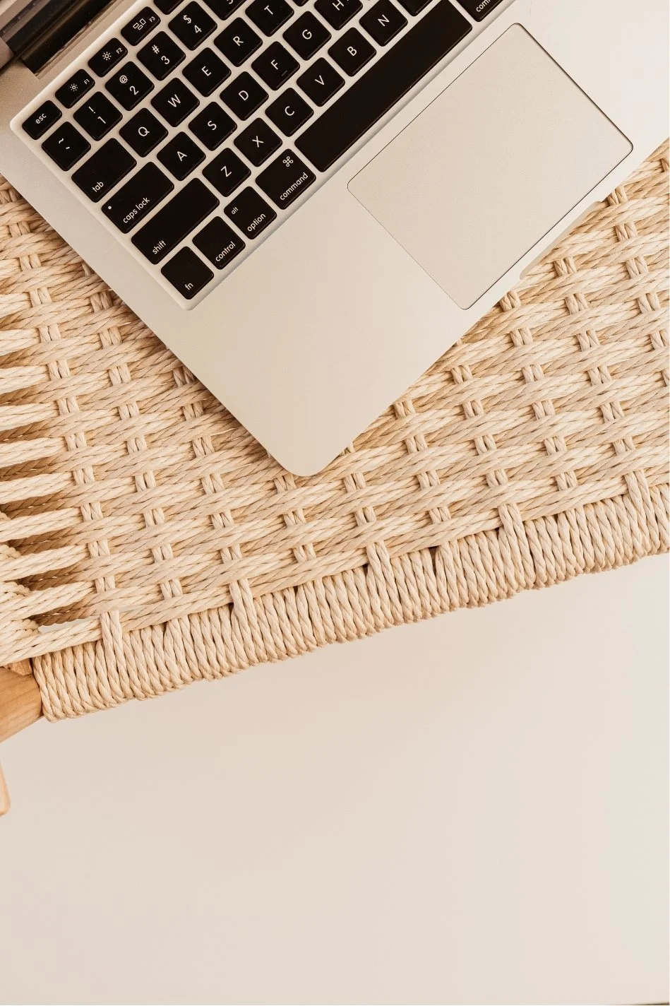 Close-up of a silver laptop on a woven beige placemat.