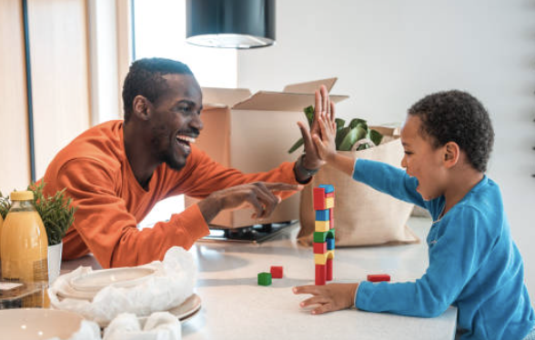 high five between a boy and man playing with stachable blocks