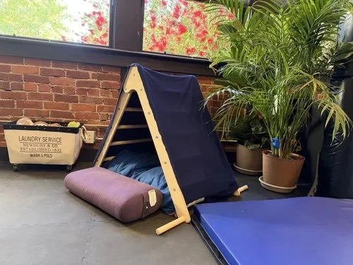 studio play space with mats and play structure and stuffies bin
