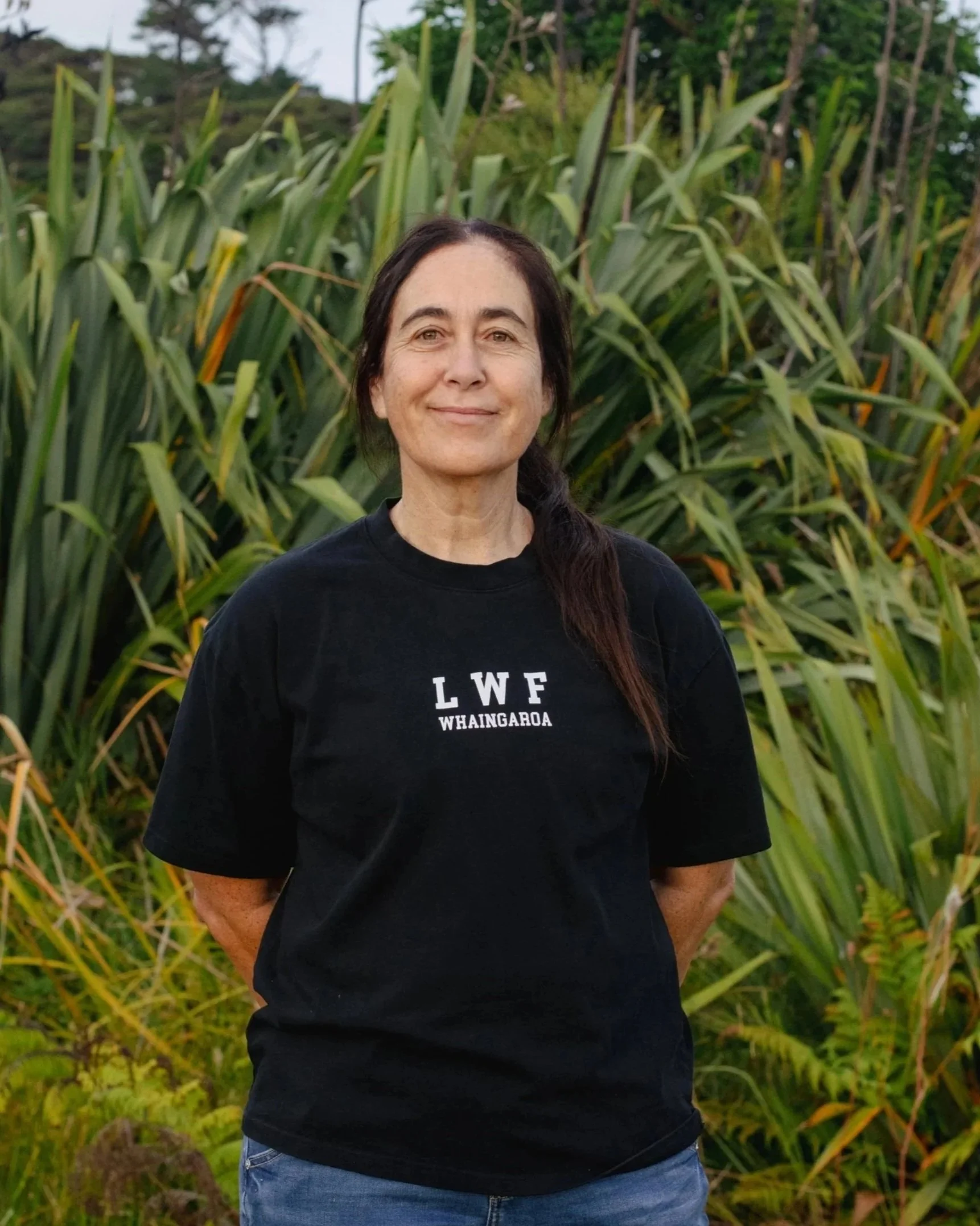 Headshot of smiling female tutor with long braids wearing a lanyard.