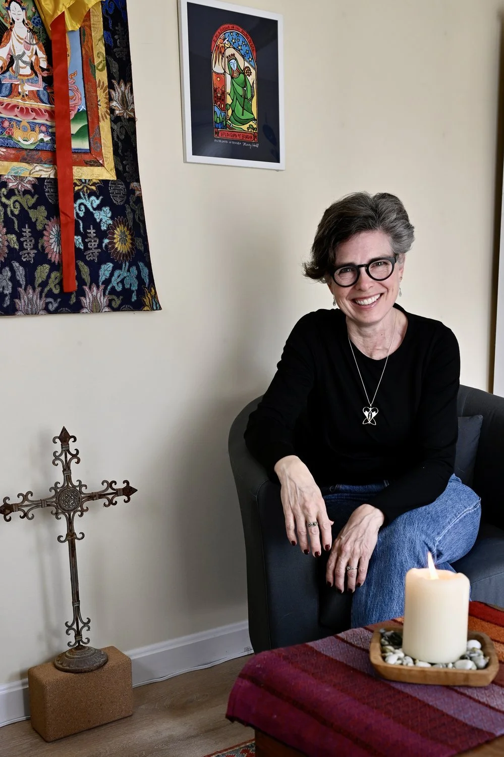 Libby Catania in her spiritual direction space with a cross and candle, providing compassionate support for faith healing