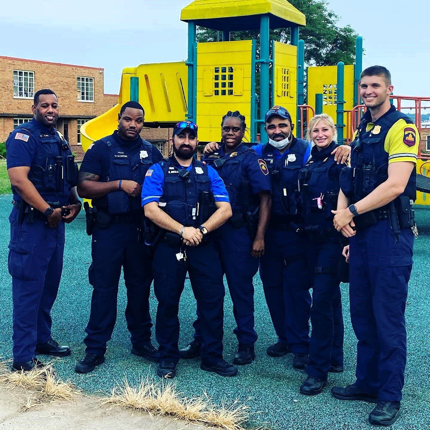 Group of uniformed police officers standing together at a playground, representing the National First Responder Peer Support Network from Badges and Breakthroughs that connects officers with trusted peers who understand the job.