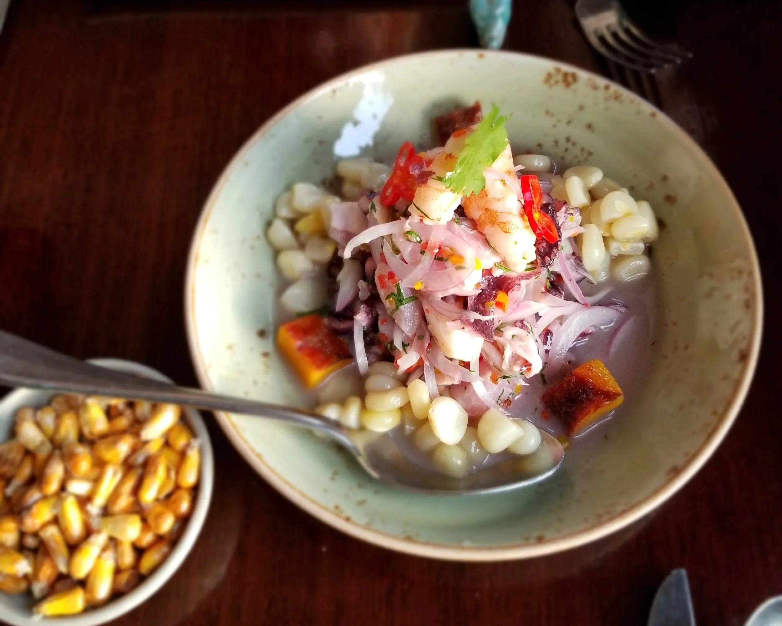 Traditional Peruvian ceviche with fresh fish, red onion, corn, and chili served in a bowl in Cusco, Peru.