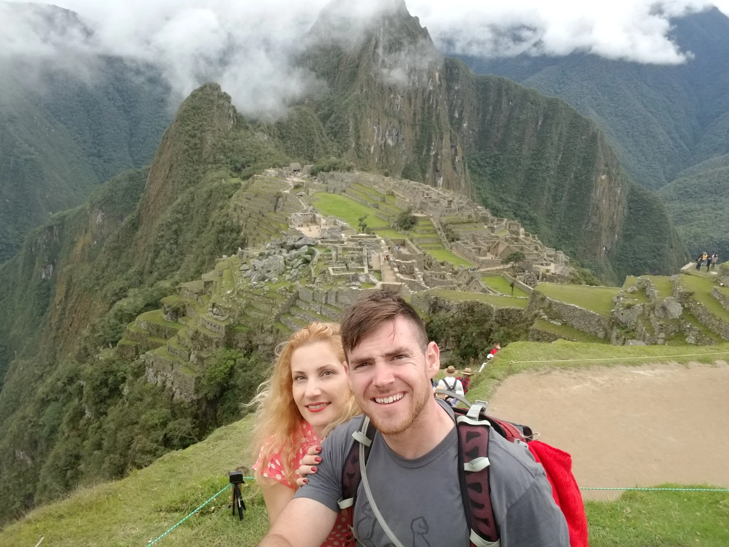 Couple selfie at the Machu Picchu viewpoint overlooking the ancient Inca citadel and Huayna Picchu mountain in Peru.