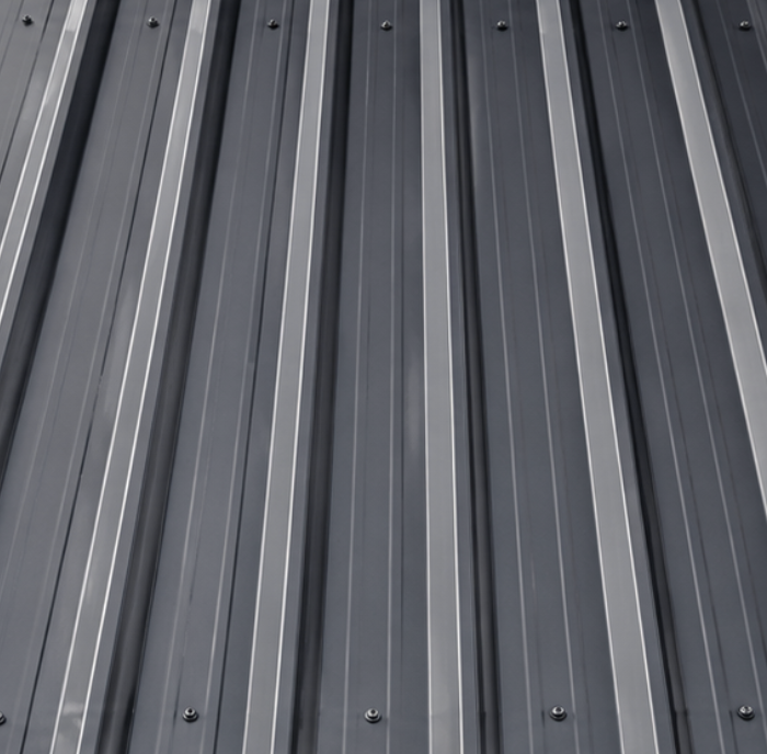 Close-up of a metal roof with parallel ridges and seams.