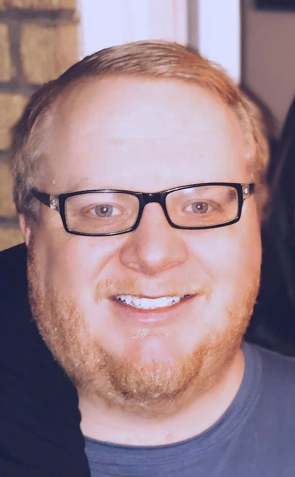 Founder Russell Nielsen, a man in his late 30s with a friendly expression, wearing high-contrast glasses.