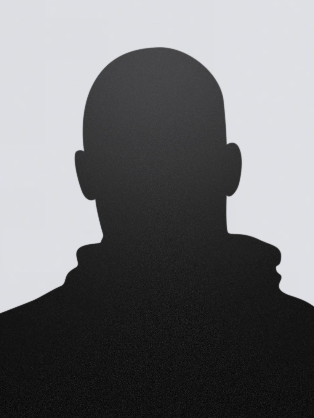 Silhouette of a person with a bald head and visible ear against a light background.
