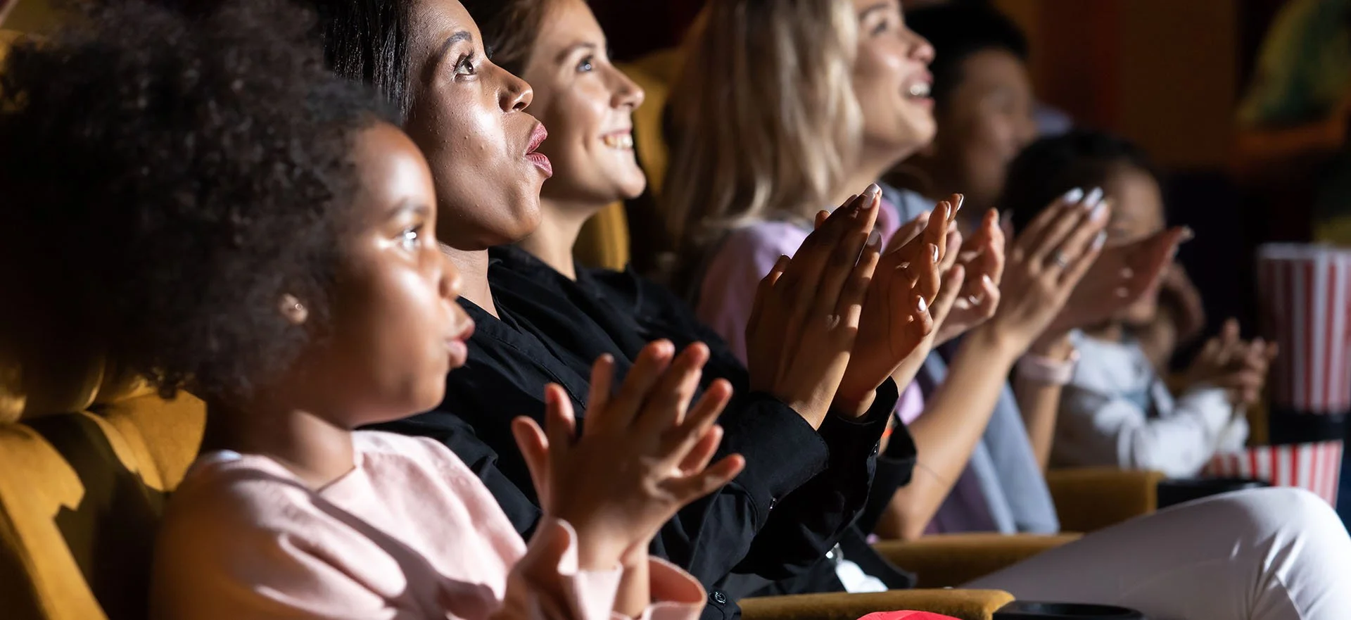A group of people sit in a theatre watching a performance