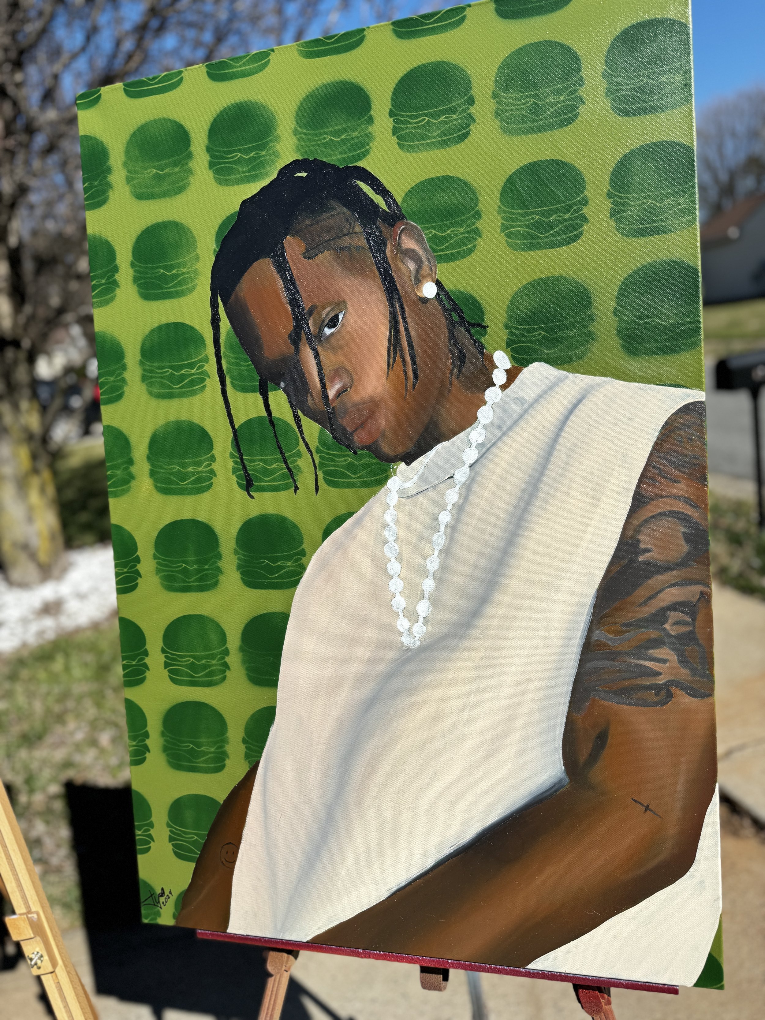 A portrait of a young man with dreadlocks, wearing a white tank top, pearl necklace, and earrings, posing against a background with repeating green burger icons.