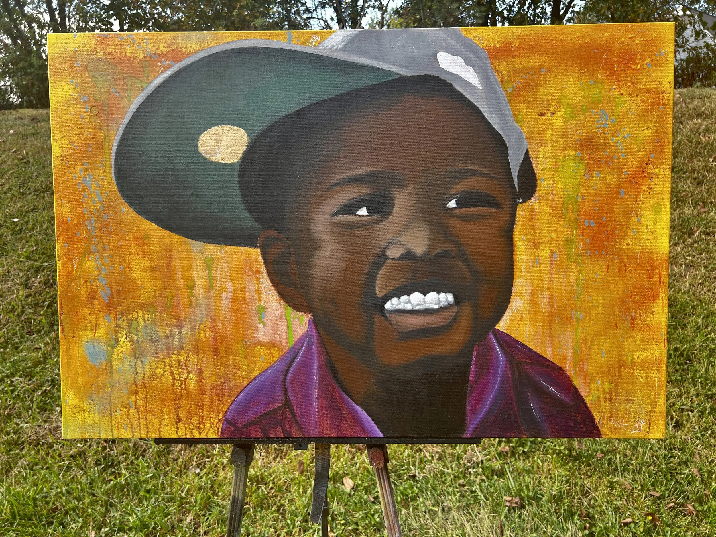 A vibrant portrait of a young boy smiling, wearing a green baseball cap and purple jacket, painted on an outdoor easel against a colorful, abstract orange and yellow background.