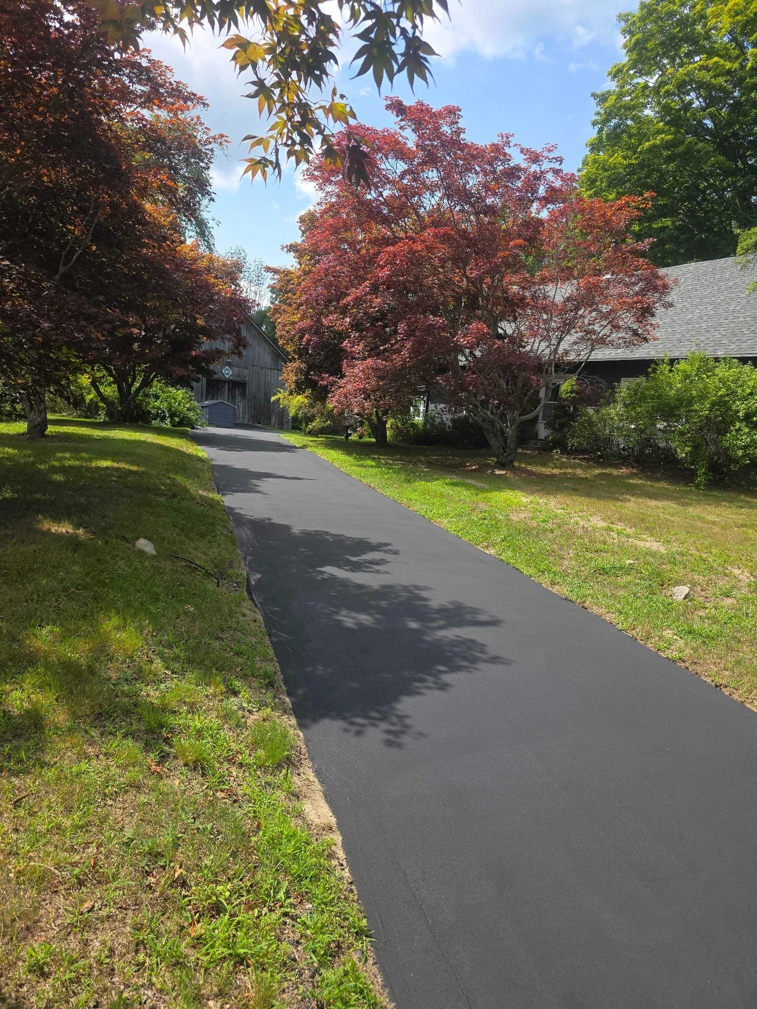 Freshly sealcoated long residential driveway in Southern New Hampshire