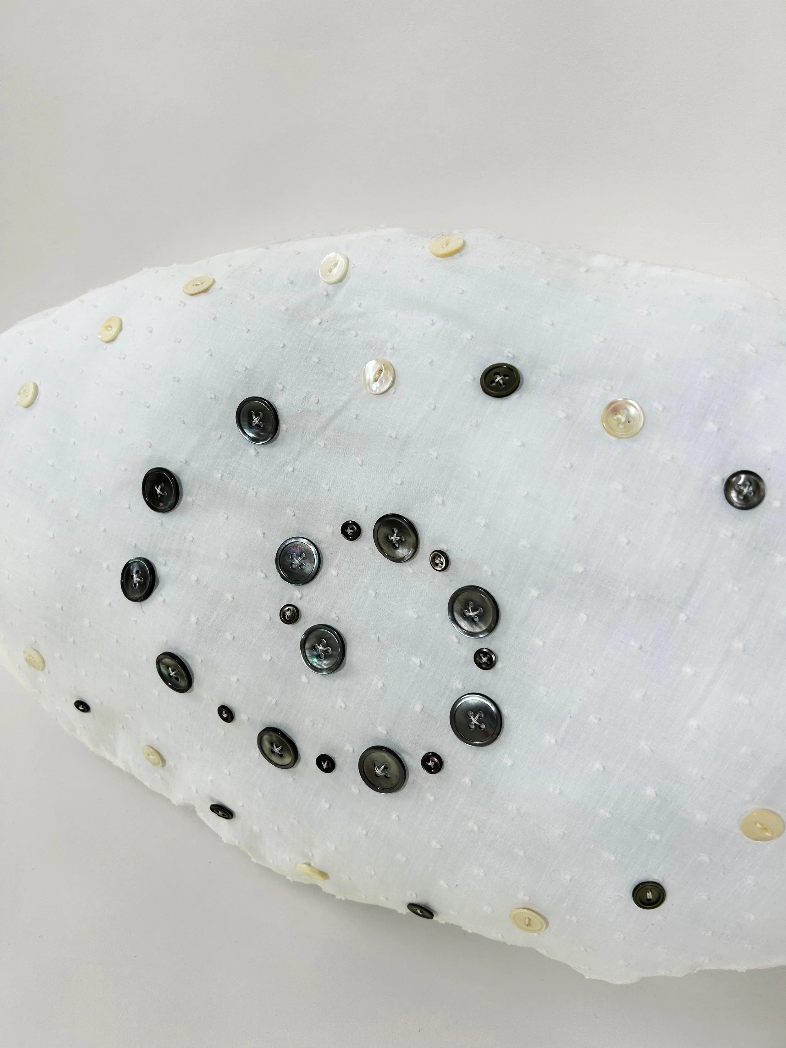 "Freshwater Double Spiral" cotton, polyester thread, mother of pearl buttons, polyfil, 13" x 23" x 3 1/2", 2023