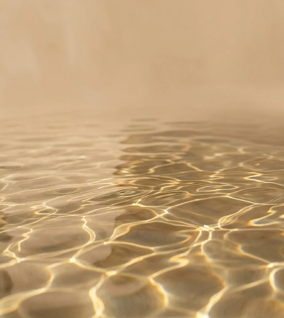 Close-up of calm water with ripples and light reflections.
