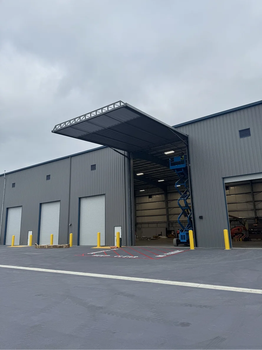 Large warehouse hydraulic door installation with lift equipment in California.