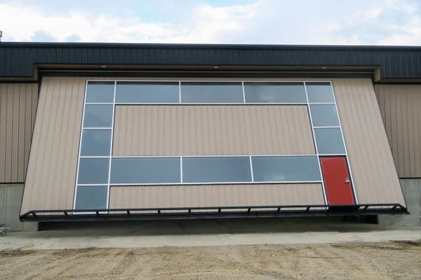 Large industrial sliding door system on metal building exterior in California.