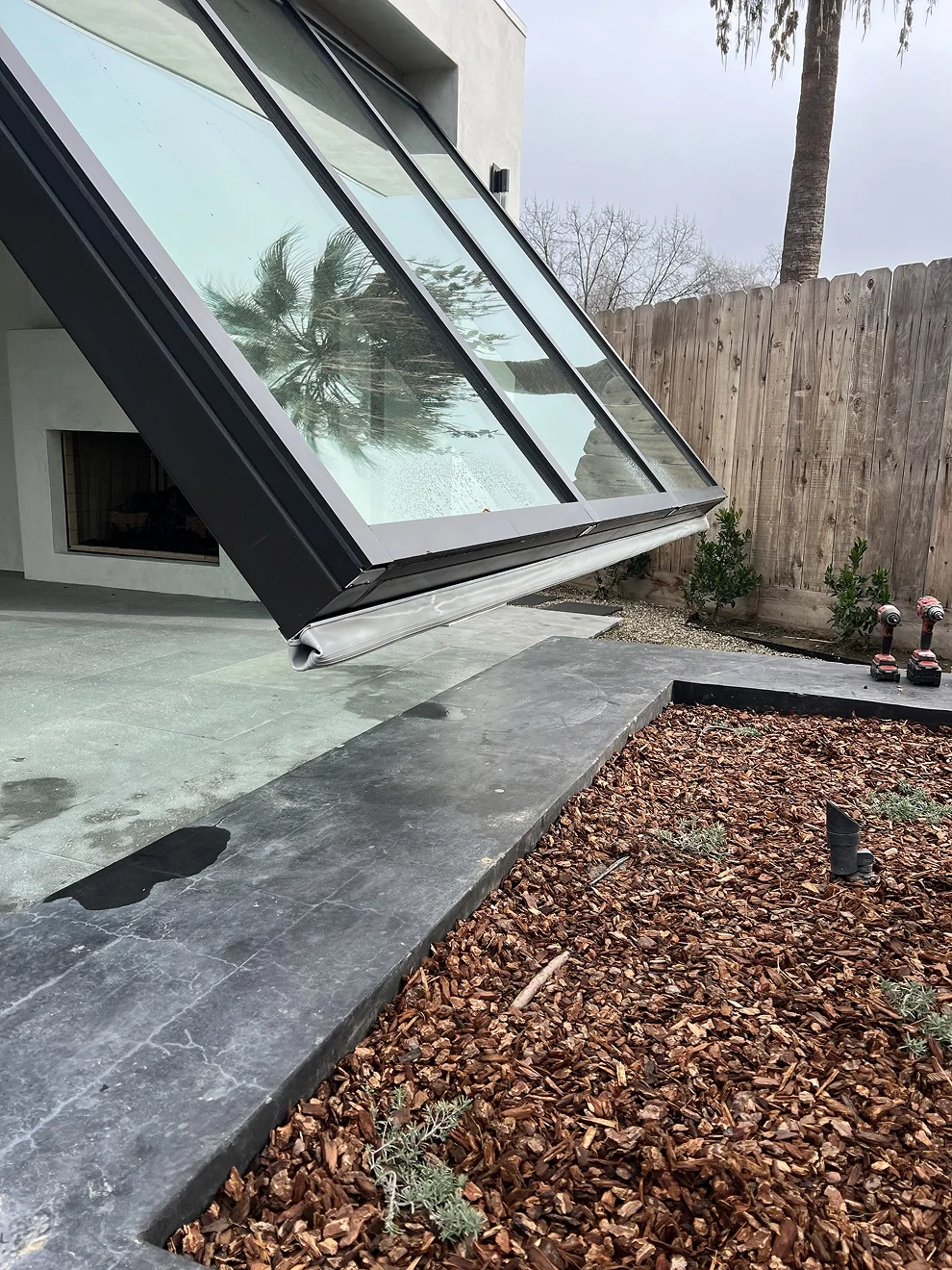 Glass hydraulic door partially open on a modern building in California.