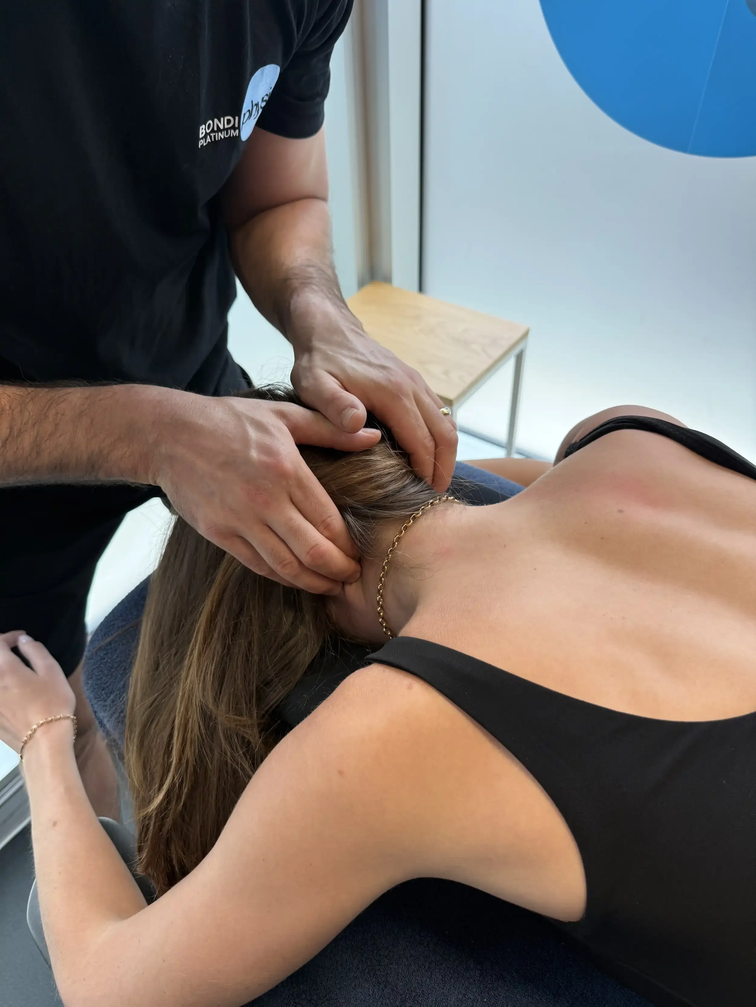 A person receiving a chiropractic or neck adjustment from a practitioner in a treatment room.