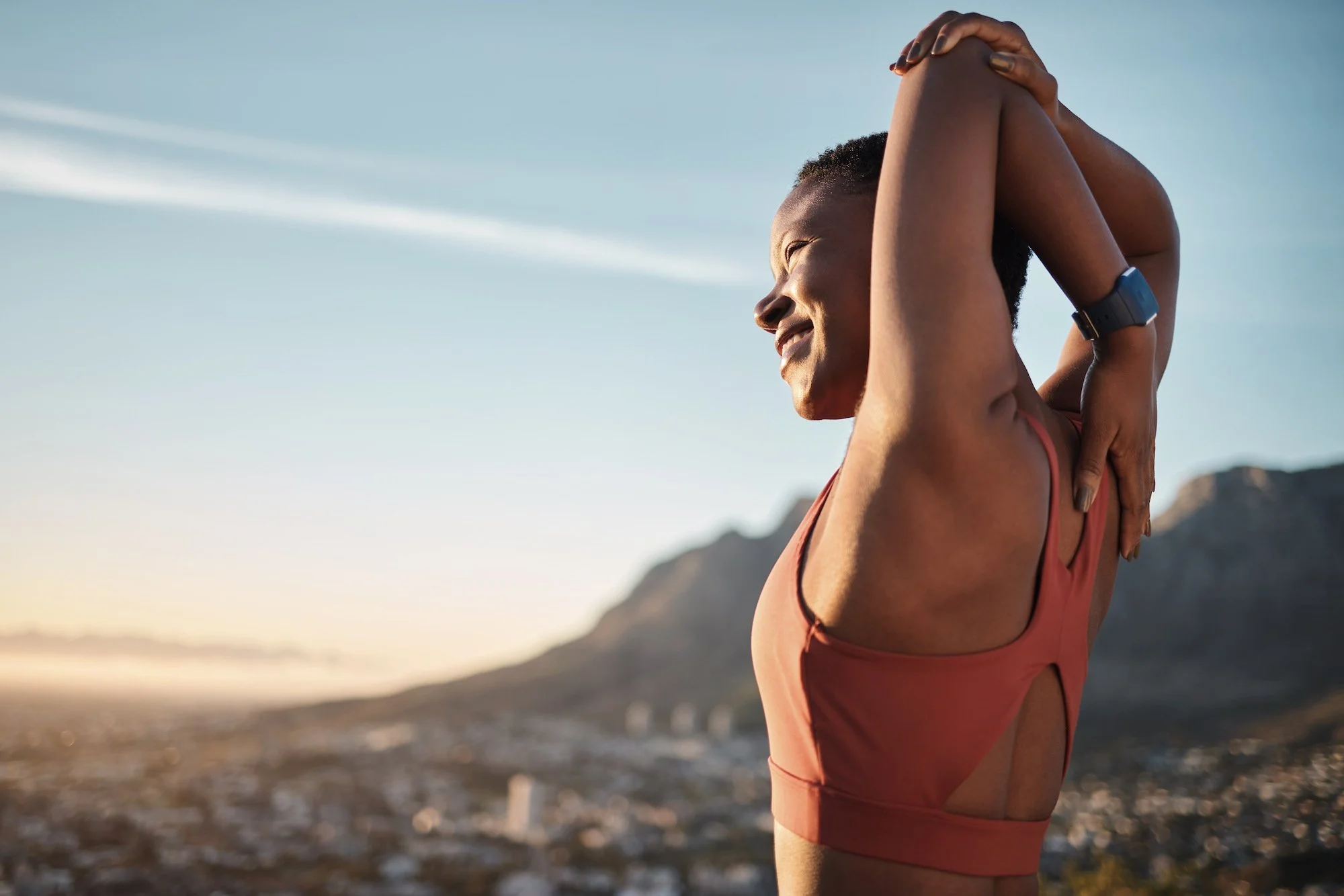 A woman stretching during outdoor exercise at sunrise or sunset