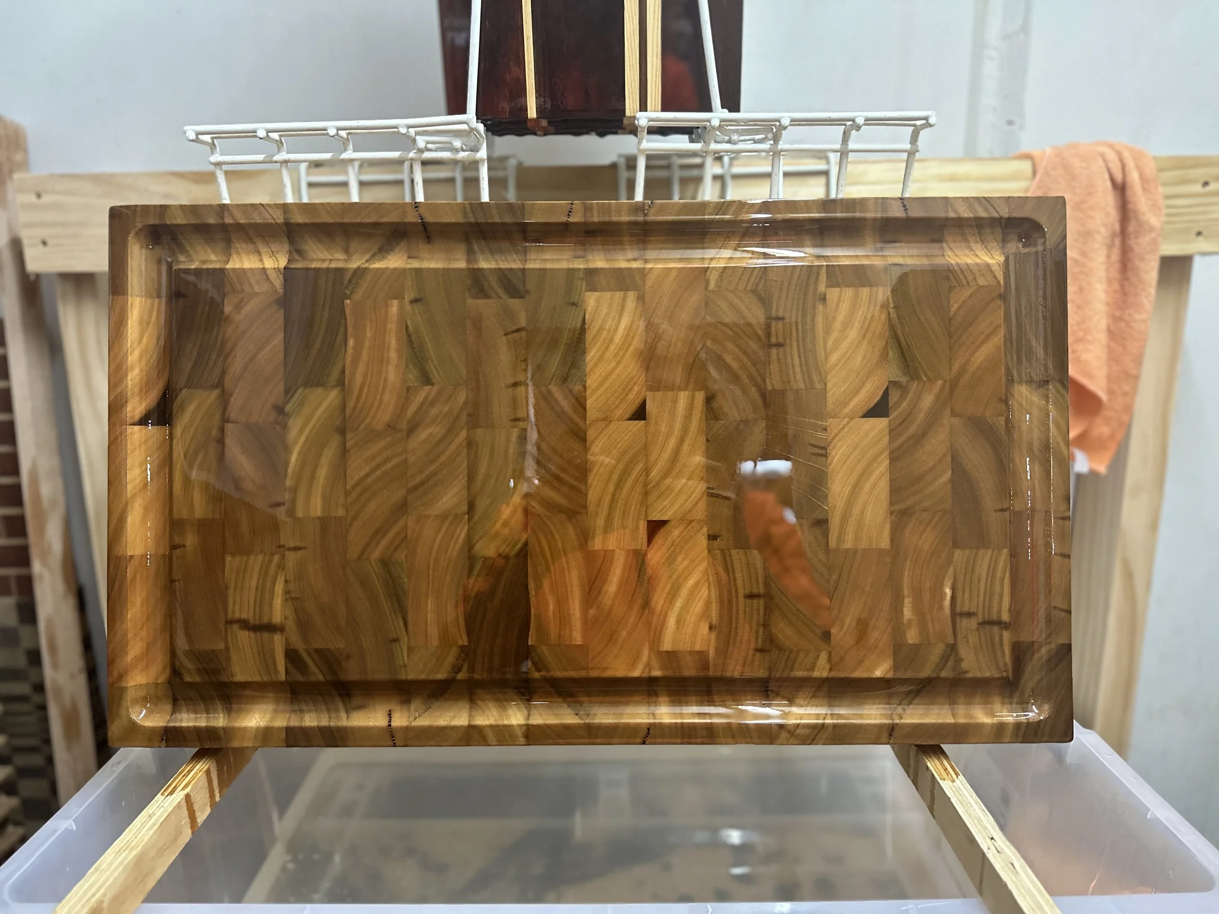 Wooden tray with a geometric pattern of wood pieces, placed on a clear plastic surface.