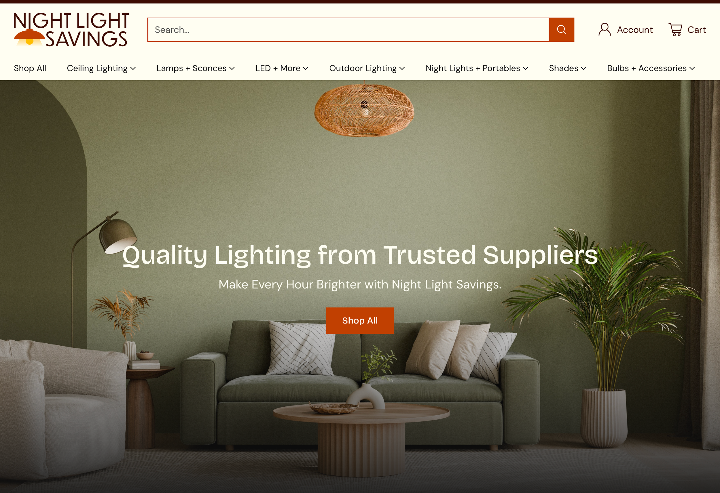 Homepage of Night Light Savings website showing a living room with a green wall, a green sofa with pillows, a round coffee table with a plant in a white vase, a beige armchair, a floor lamp, and a wicker pendant light, with text overlay advertising quality lighting from trusted suppliers.