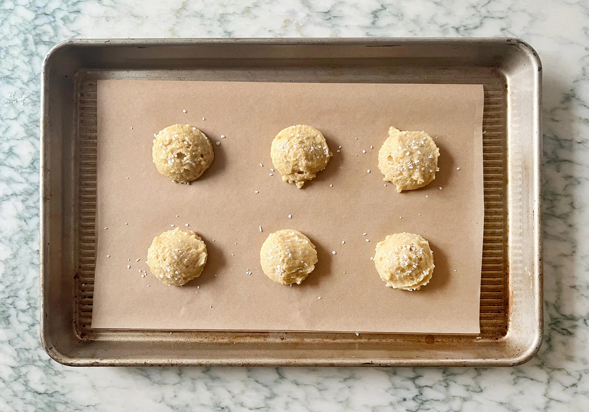 step 3 balls of cookie dough on cookie sheet sprinkled with salt