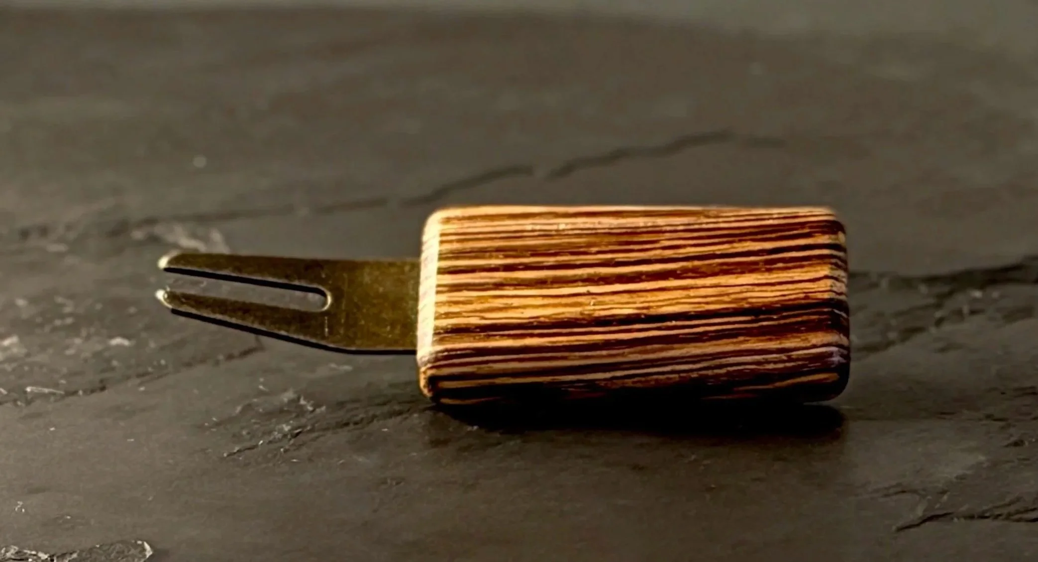 Handcrafted zebrawood golf divot tool with antiqued brass hardware