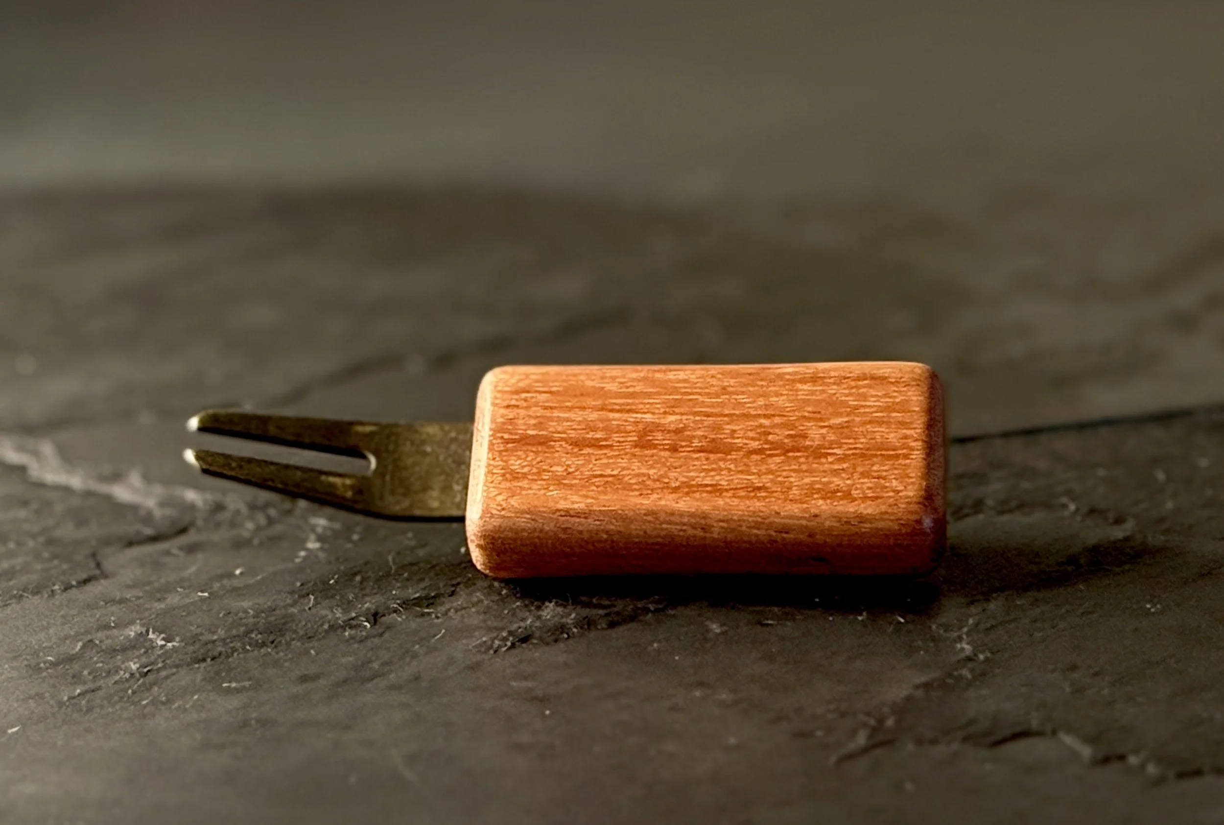Handcrafted bubinga wood golf divot tool with antiqued brass hardware