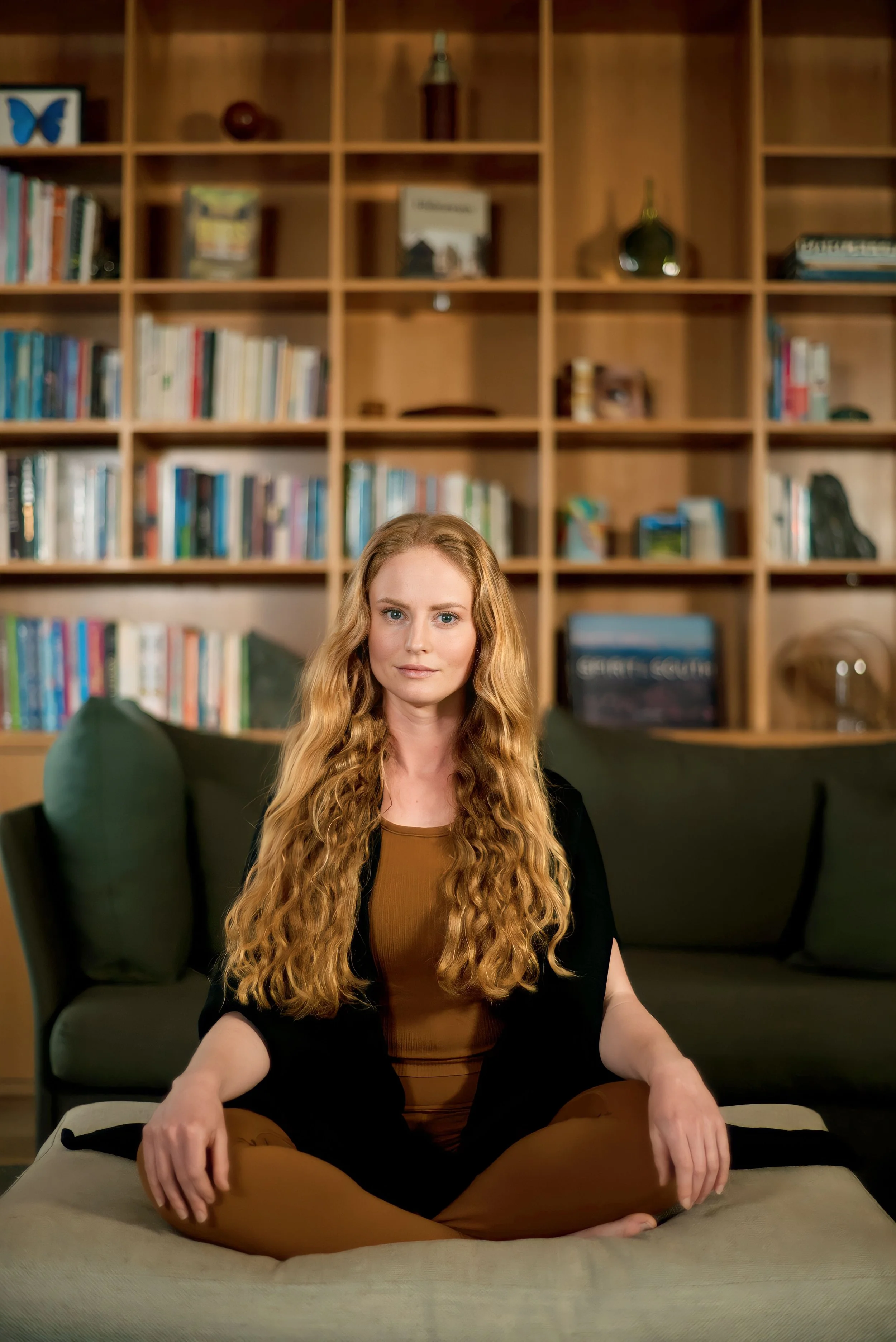 Anna Chaparro, IFS practitioner, seated in front of bookshelf