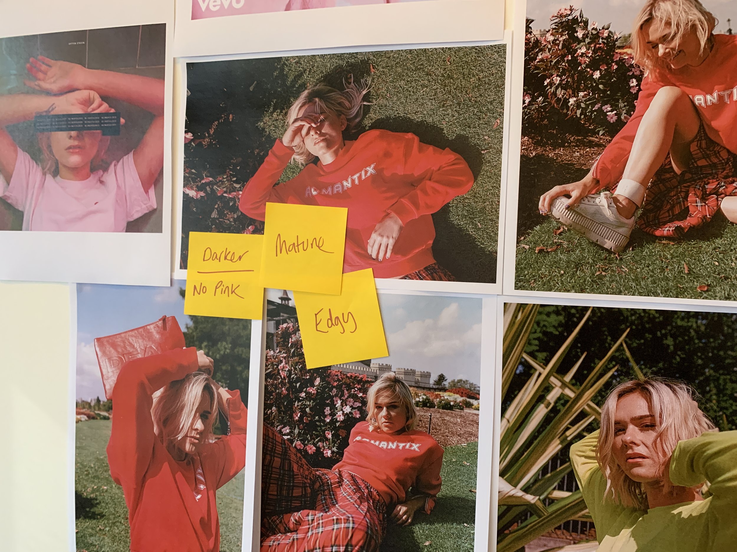 A collage of people outdoors, including a woman in a pink shirt lying on the grass, a woman in a red sweatshirt and plaid skirt sitting on the grass, and a woman in a yellow shirt, all with various postures and expressions, surrounded by greenery and flowers.