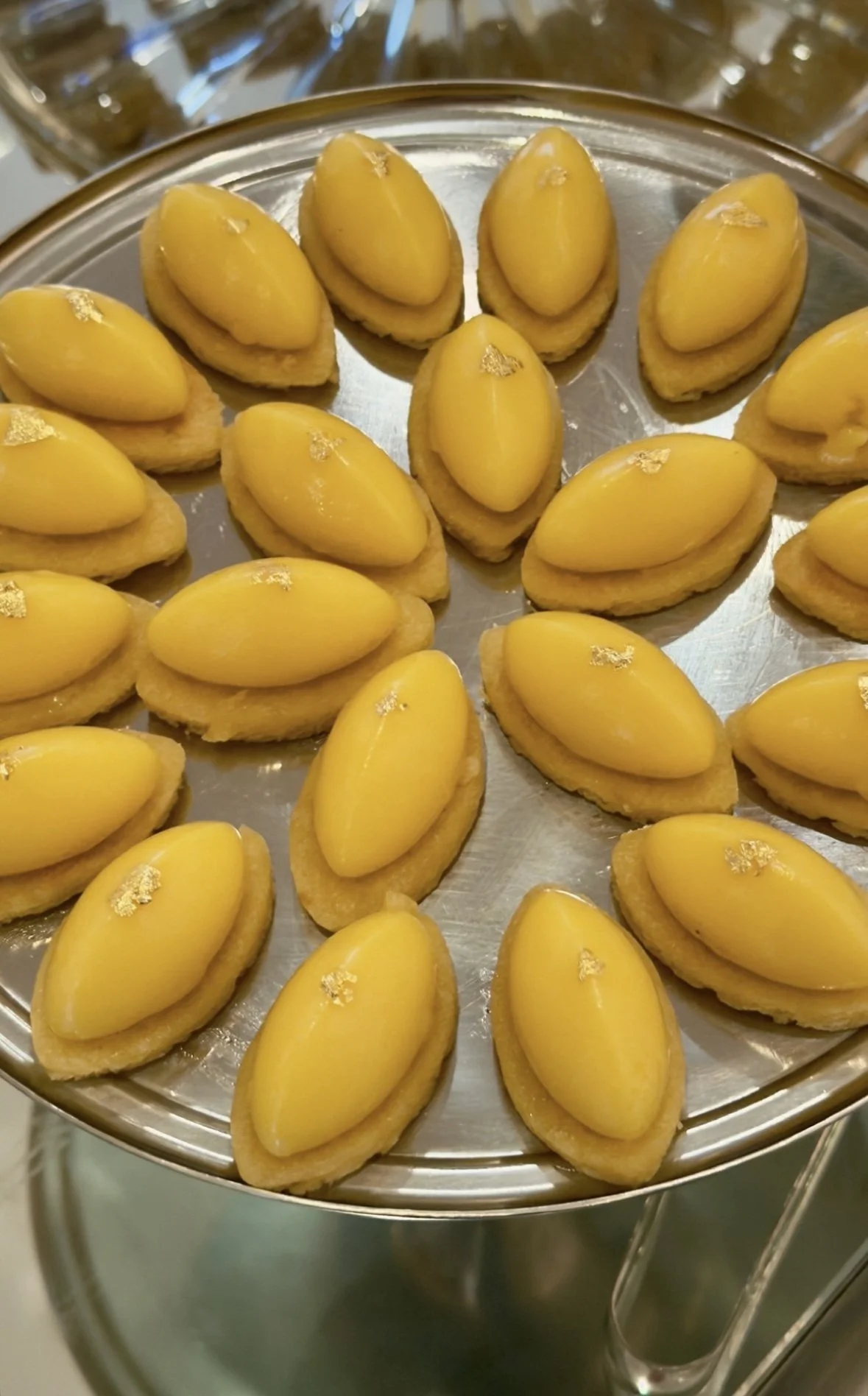 Petites tartes avec une garniture jaune, décorées de feuilles d'or.