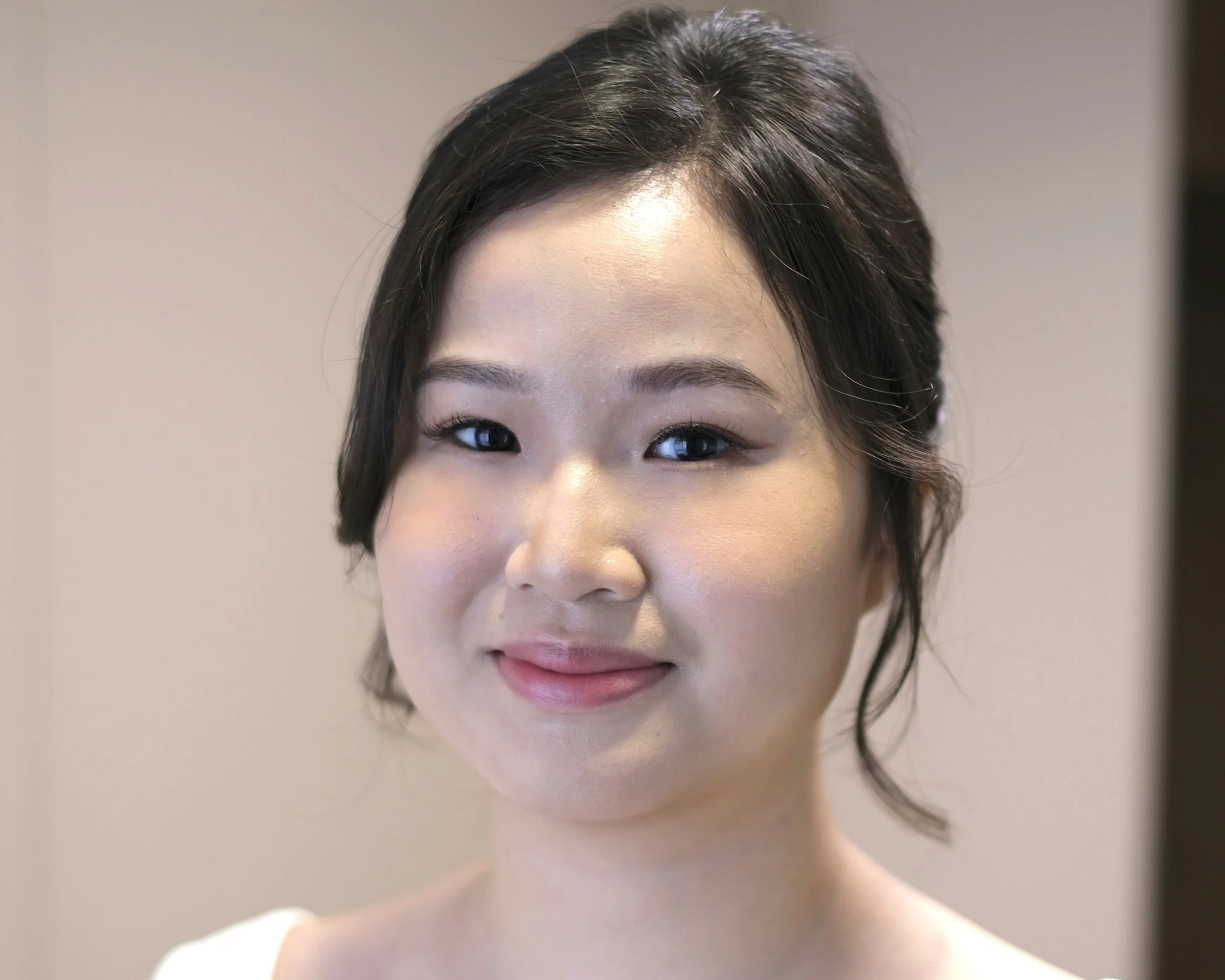 Refined bridal makeup and timeless wedding updo hairstyle.