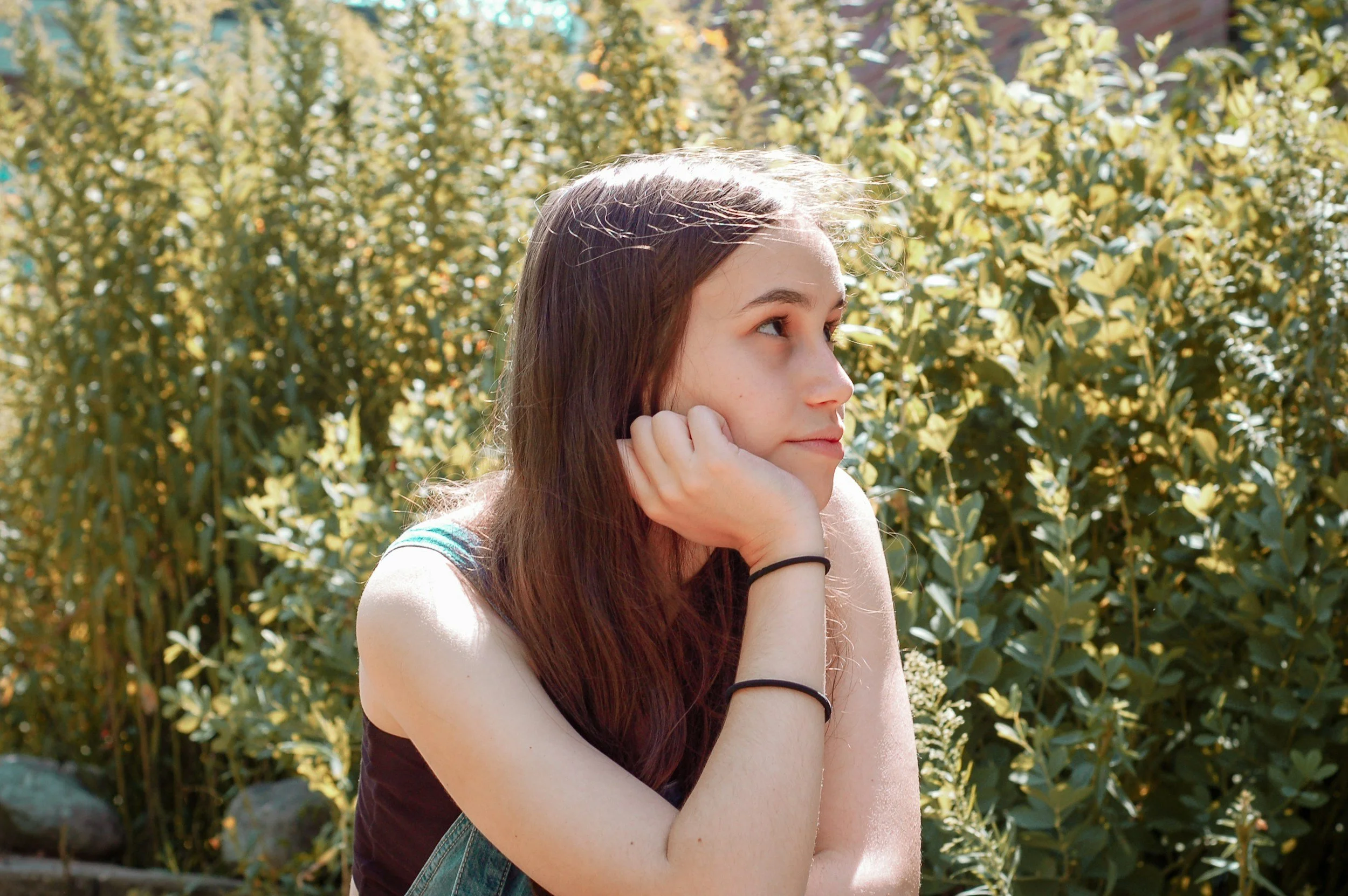 Anxious teenager sitting in nature looking away