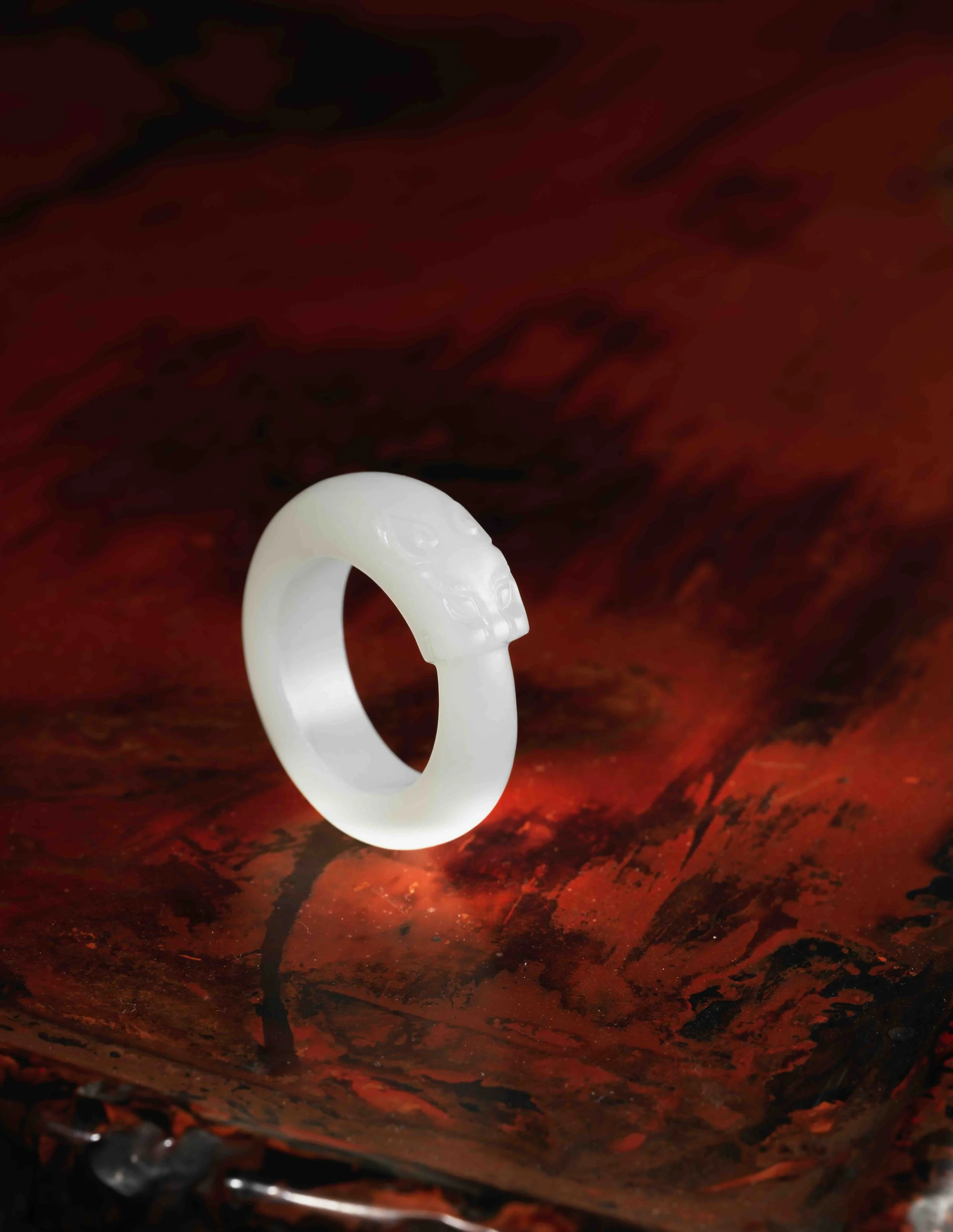 A white jade ring carved with a tiger’s head biting its own tail, 
China: Qianlong period (1736–95)