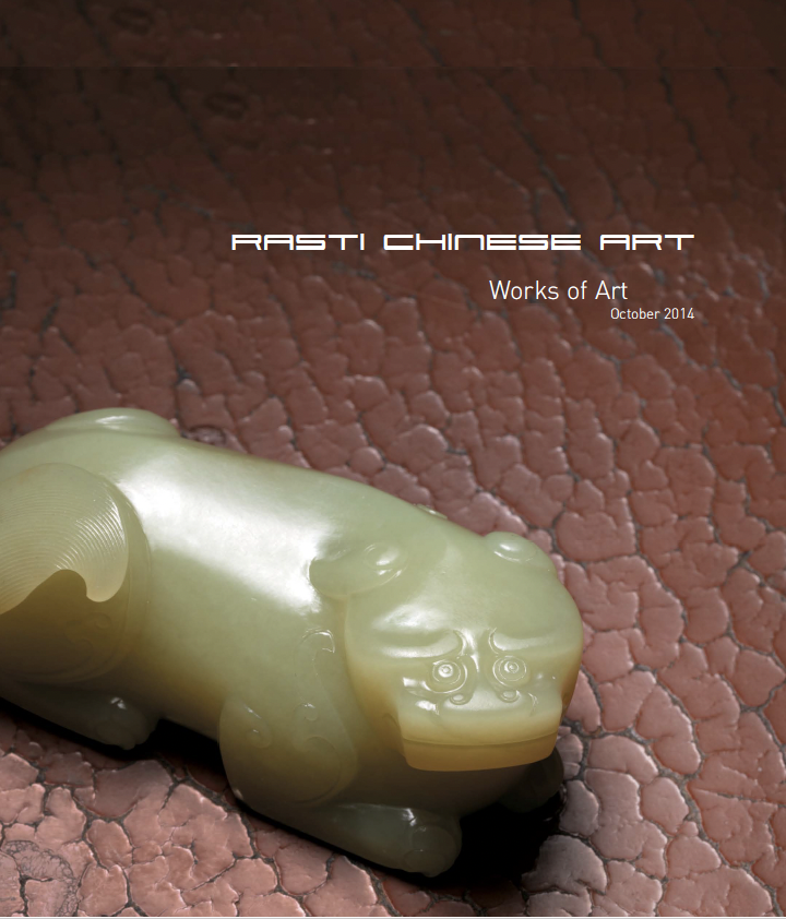 Close-up of a jade mythical animal on a textured surface. The statue is intricately carved with a detailed face and body, characteristic of Chinese art.