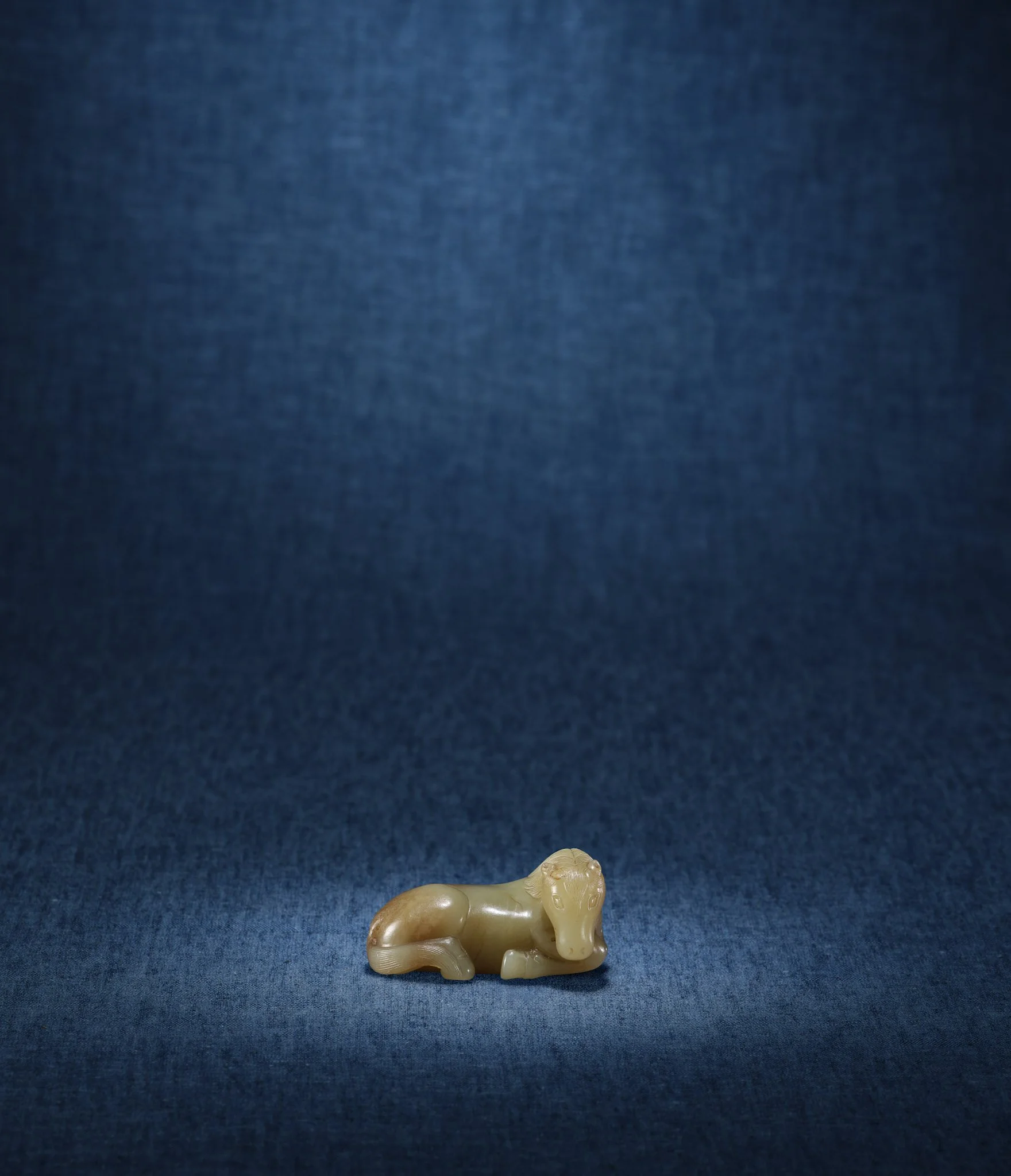 A yellow and slightly russet jade model of a recumbent Mongolian horse,
China, Song to early Yuan dynasty, 10th to 13th century
