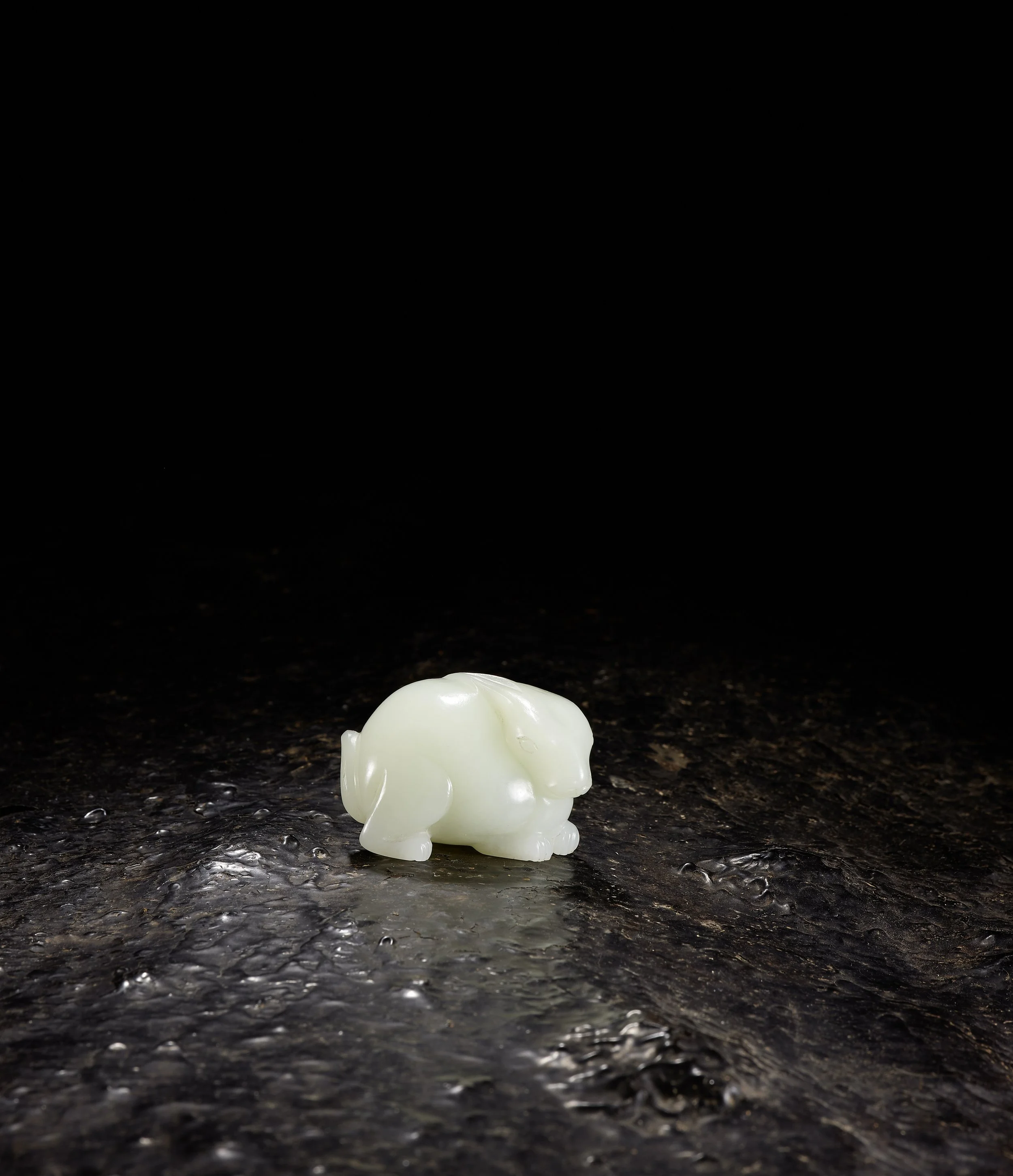 A white jade pebble-form model of a crouching rabbit, 
China: Qianlong period (1736–95)