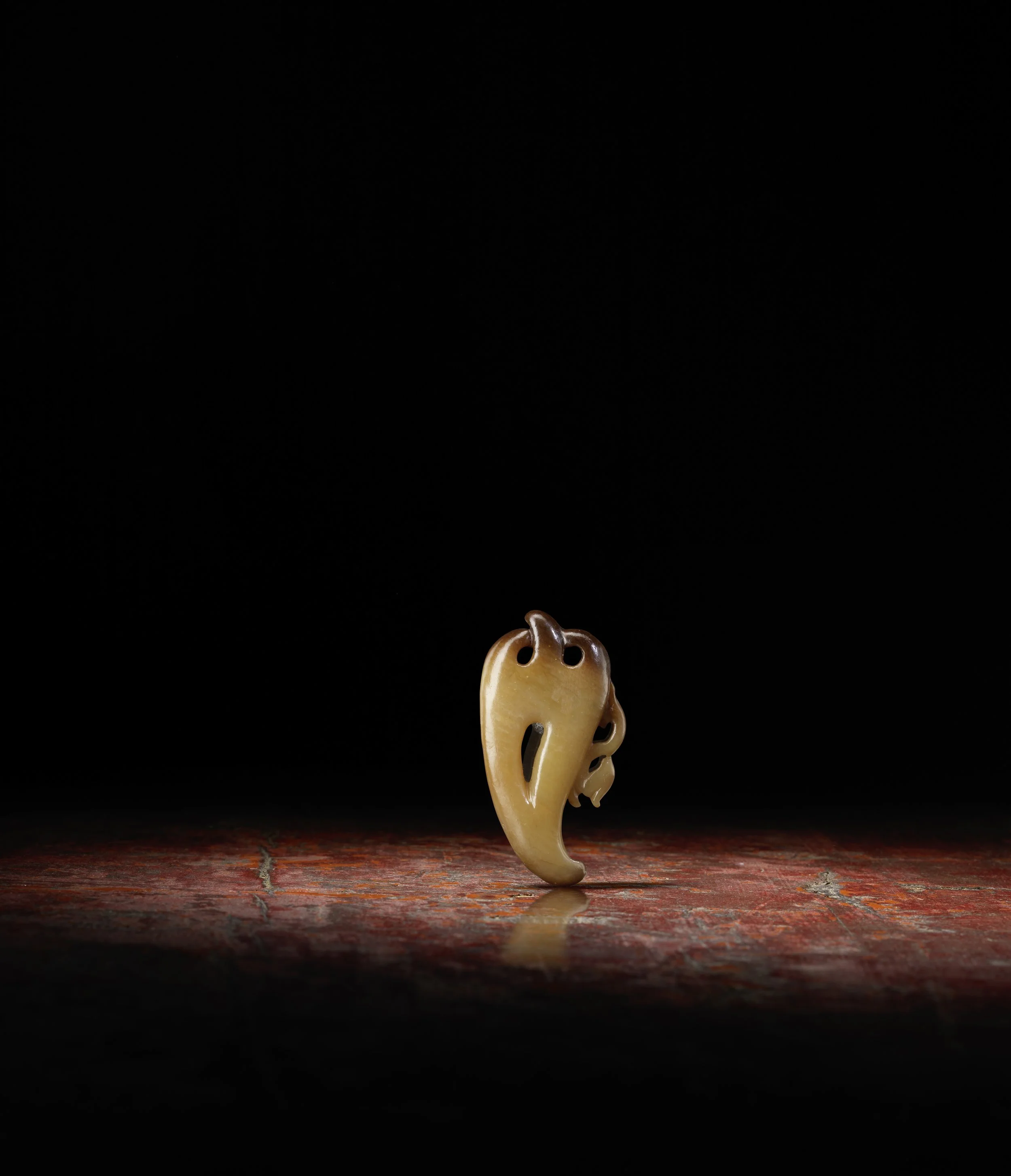 A deep and light russet openwork pendant in the form of an abstract phoenix,
China: Tang to Song dynasty, 7th-10th century