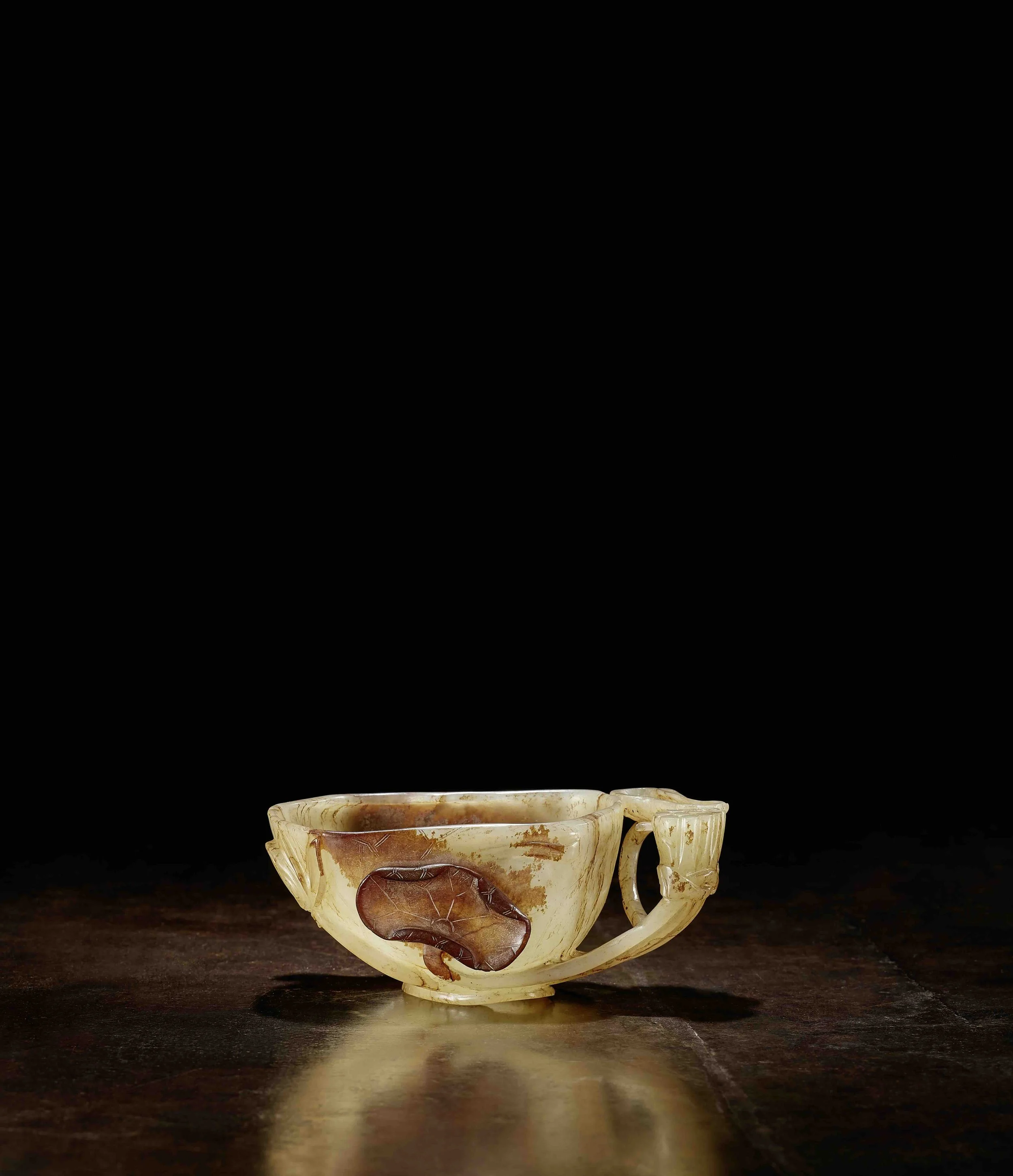 A pale celadon and deep russet jade cup in the form of an open lotus, 
China: Song dynasty (960-1279)