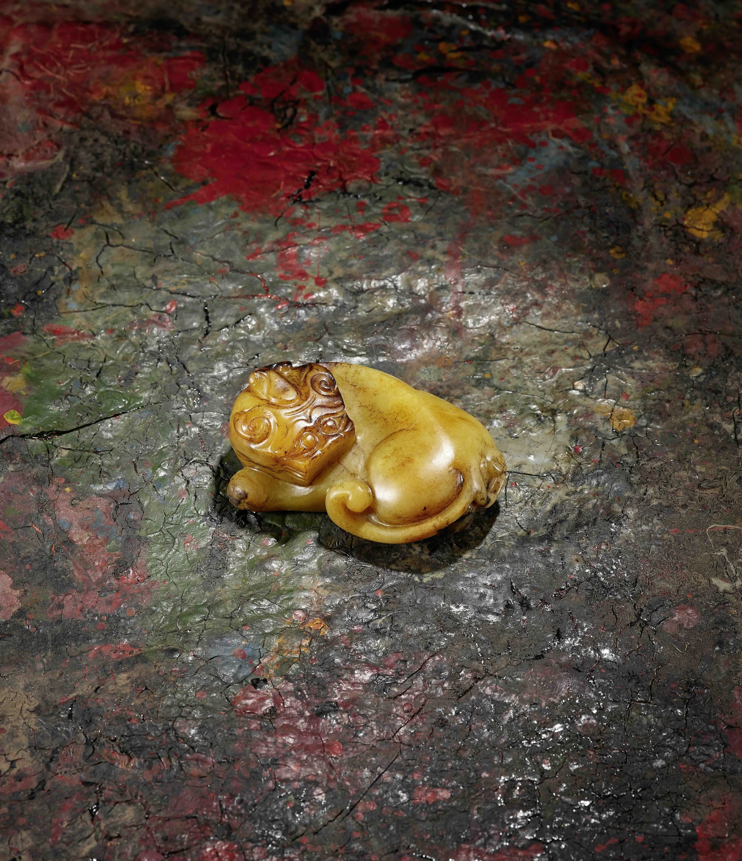 A yellow and russet jade model of a recumbent mythical beast, 
China: Ming dynasty, early 17th century
