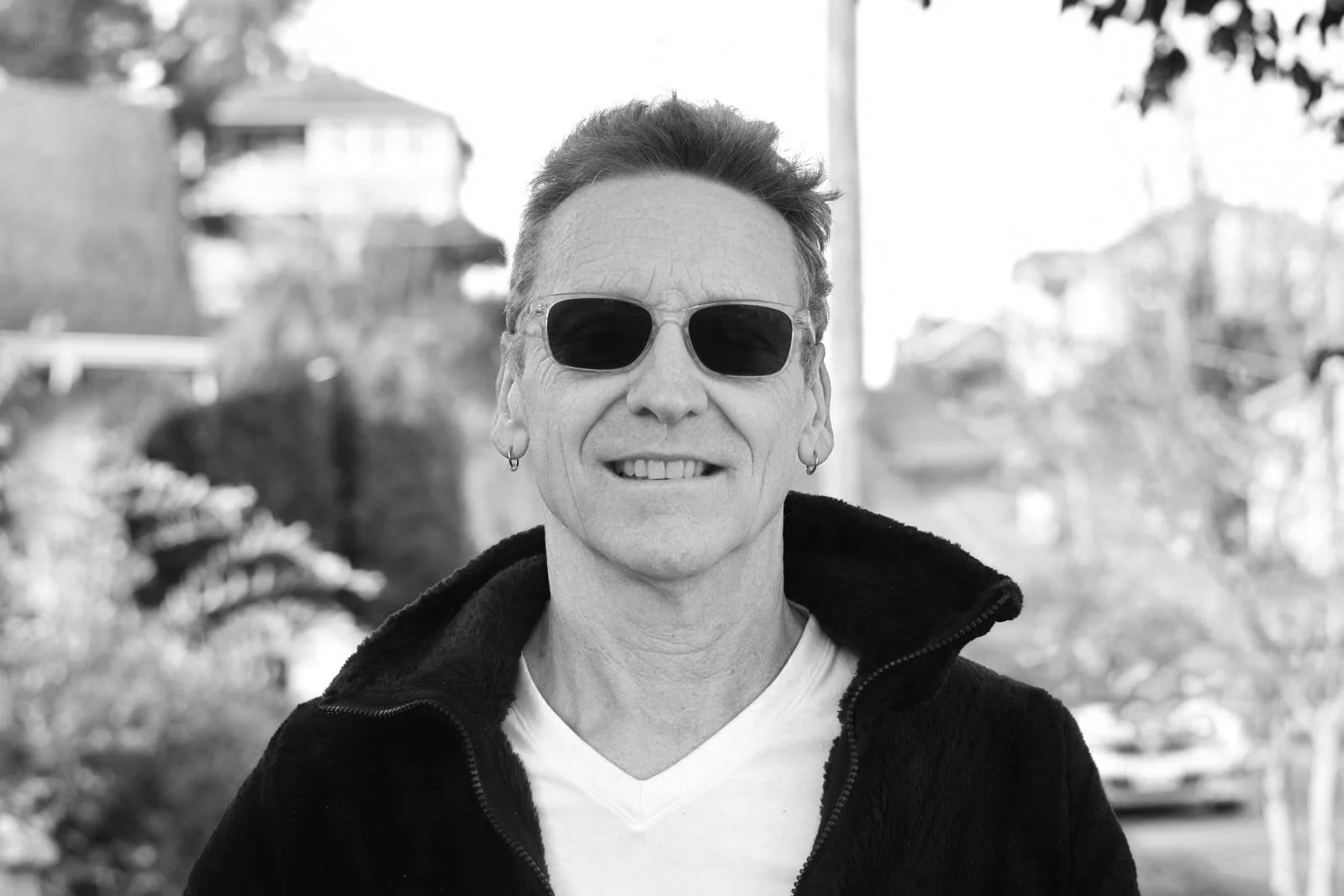 black and white photo of a man with short hair wearing sunglasses.