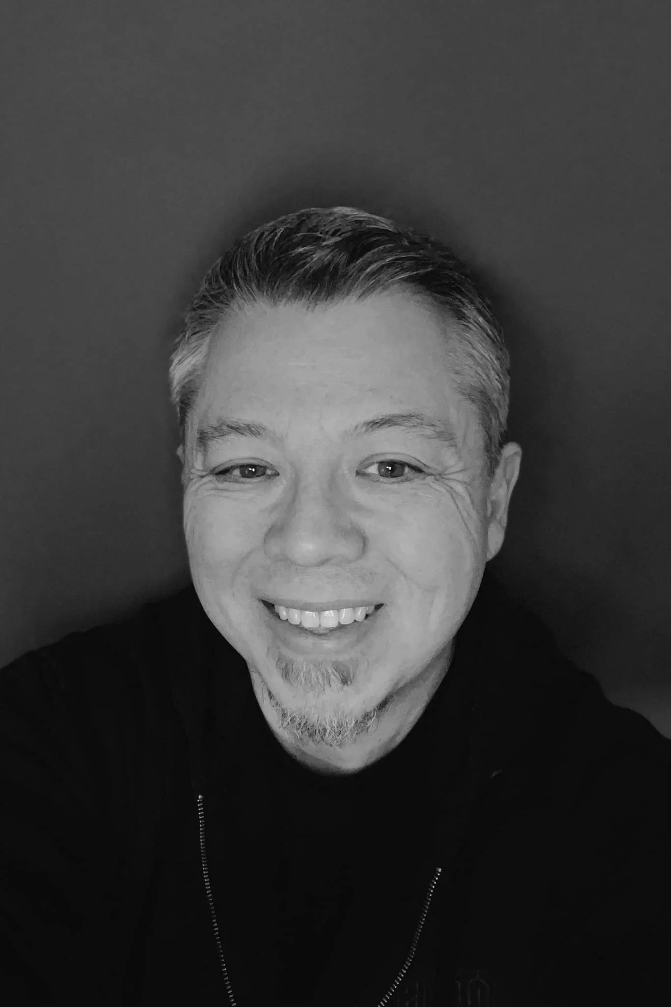 Black and white photo of a man with a gotee.