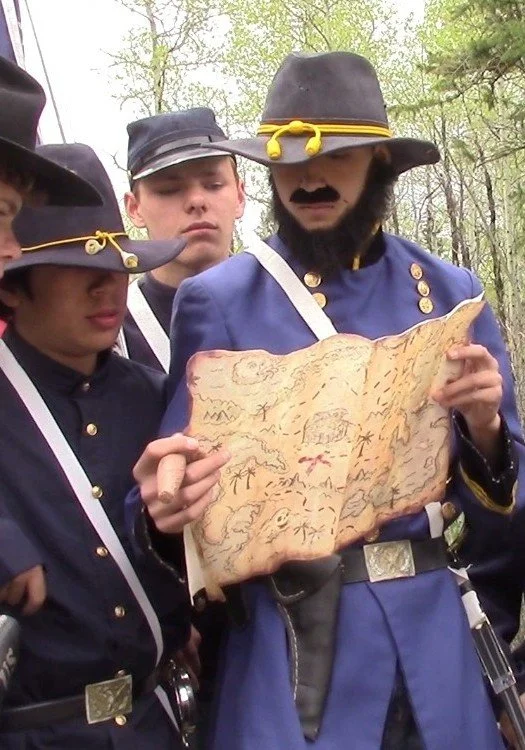 Students at a Civil War Battle reenactment, as a US Union general and his officers consulting a map.