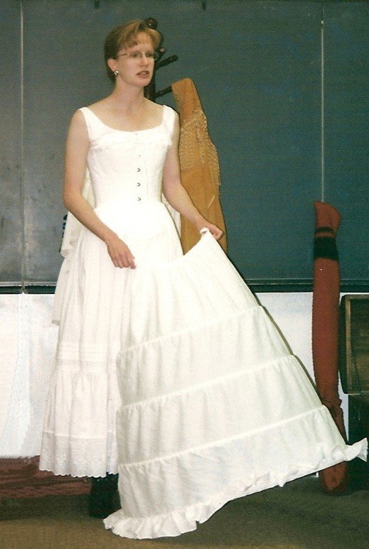 Sharon Guli demonstrating the underpinnings such as a chemise, petticoat, and hoop, that would have been worn under a dress of a Civil War lady.